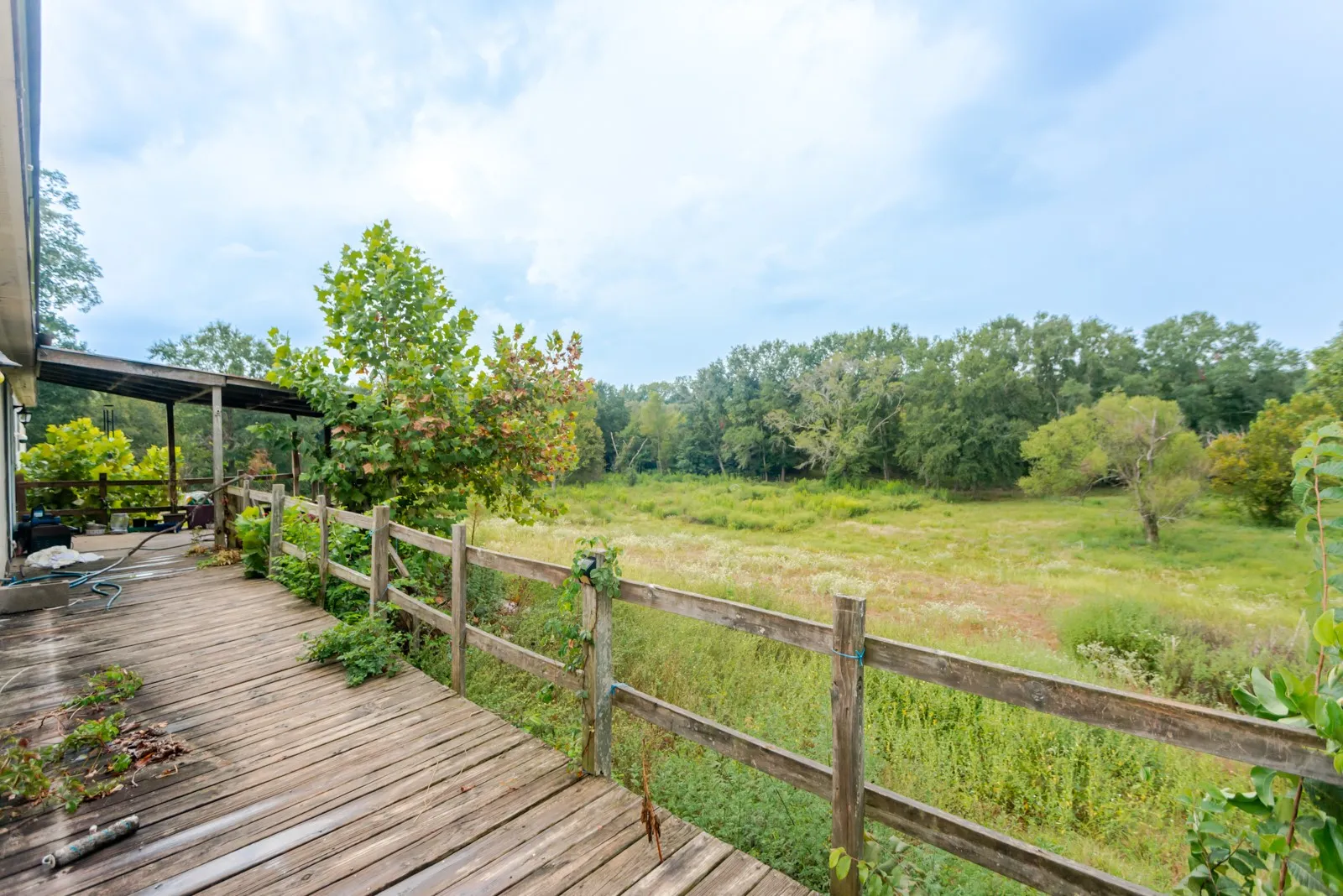 Expansive outdoor deck with a natural wood finish, partially covered by a protective awning