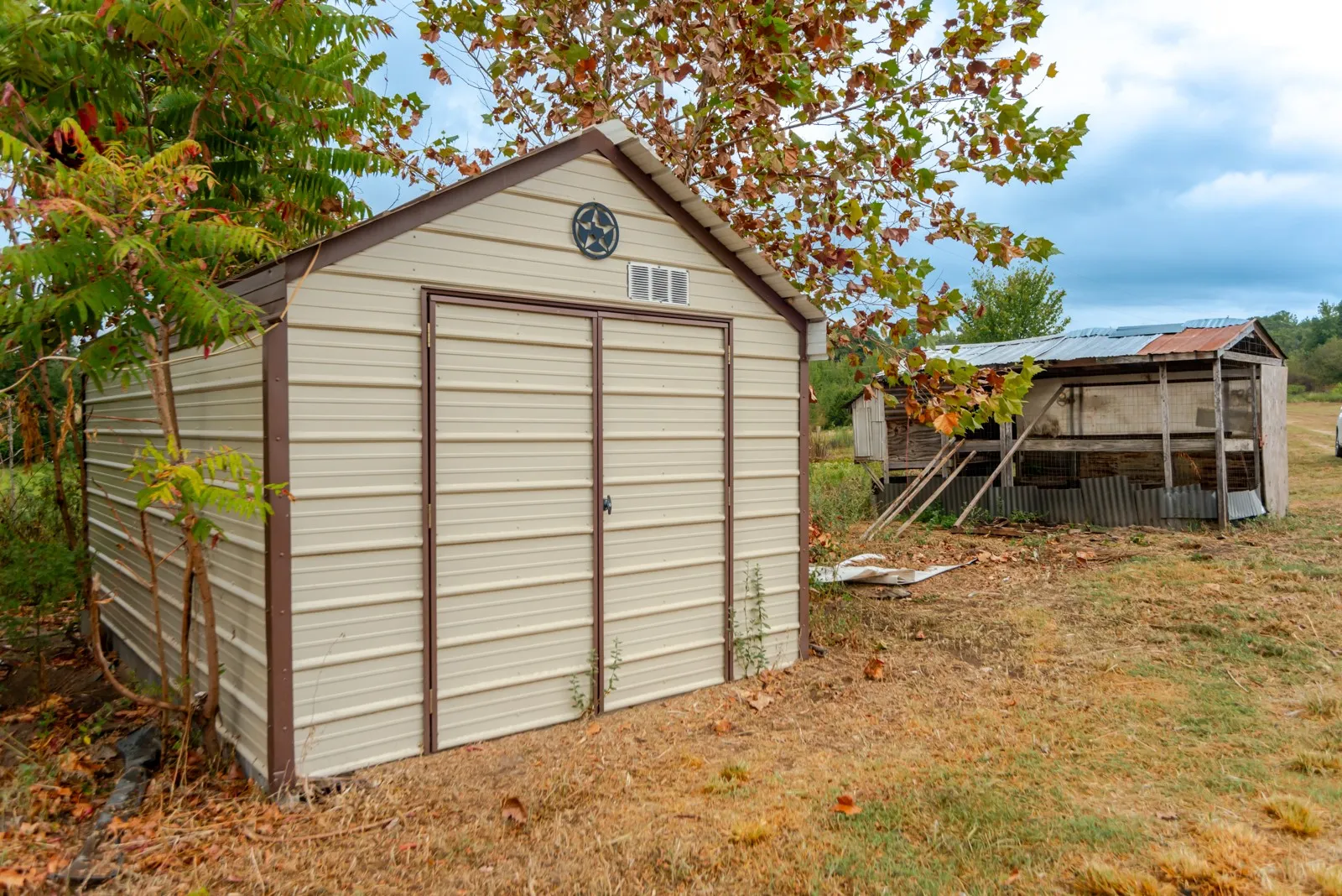Detached metal storage shed with double doors and a gable vent