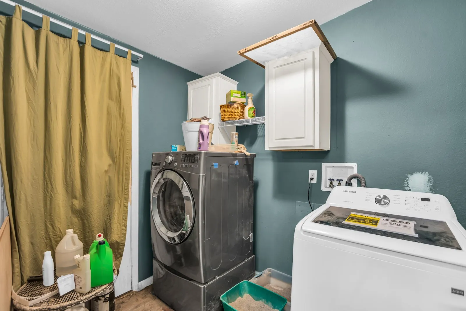 Laundry area with white cabinetry and wall-mounted shelving