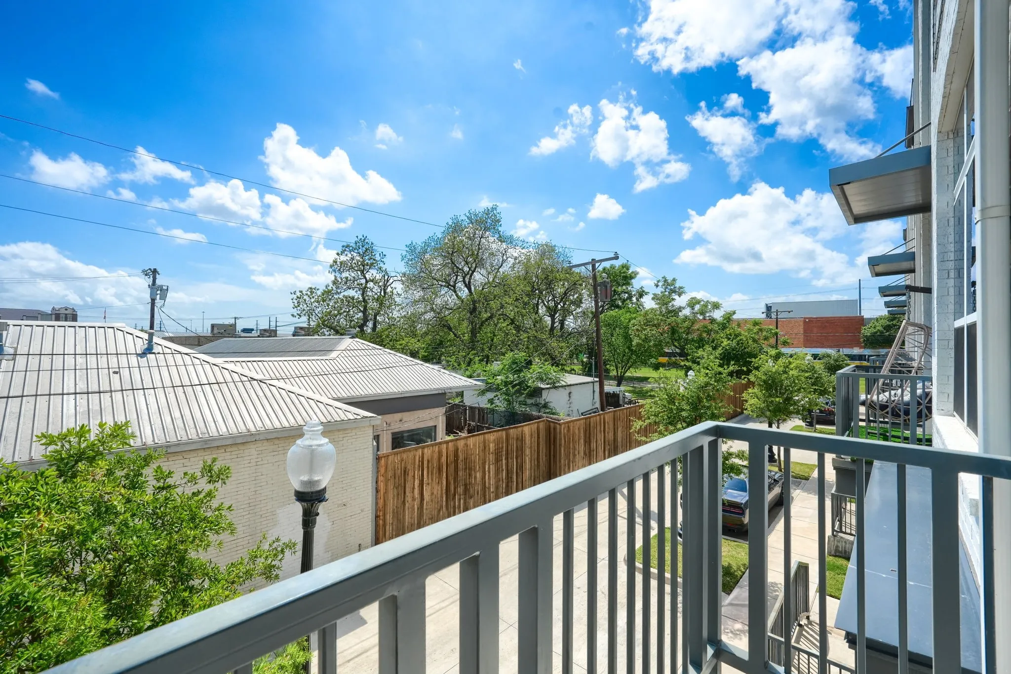 Private balcony featuring metal railings and urban landscaping elements