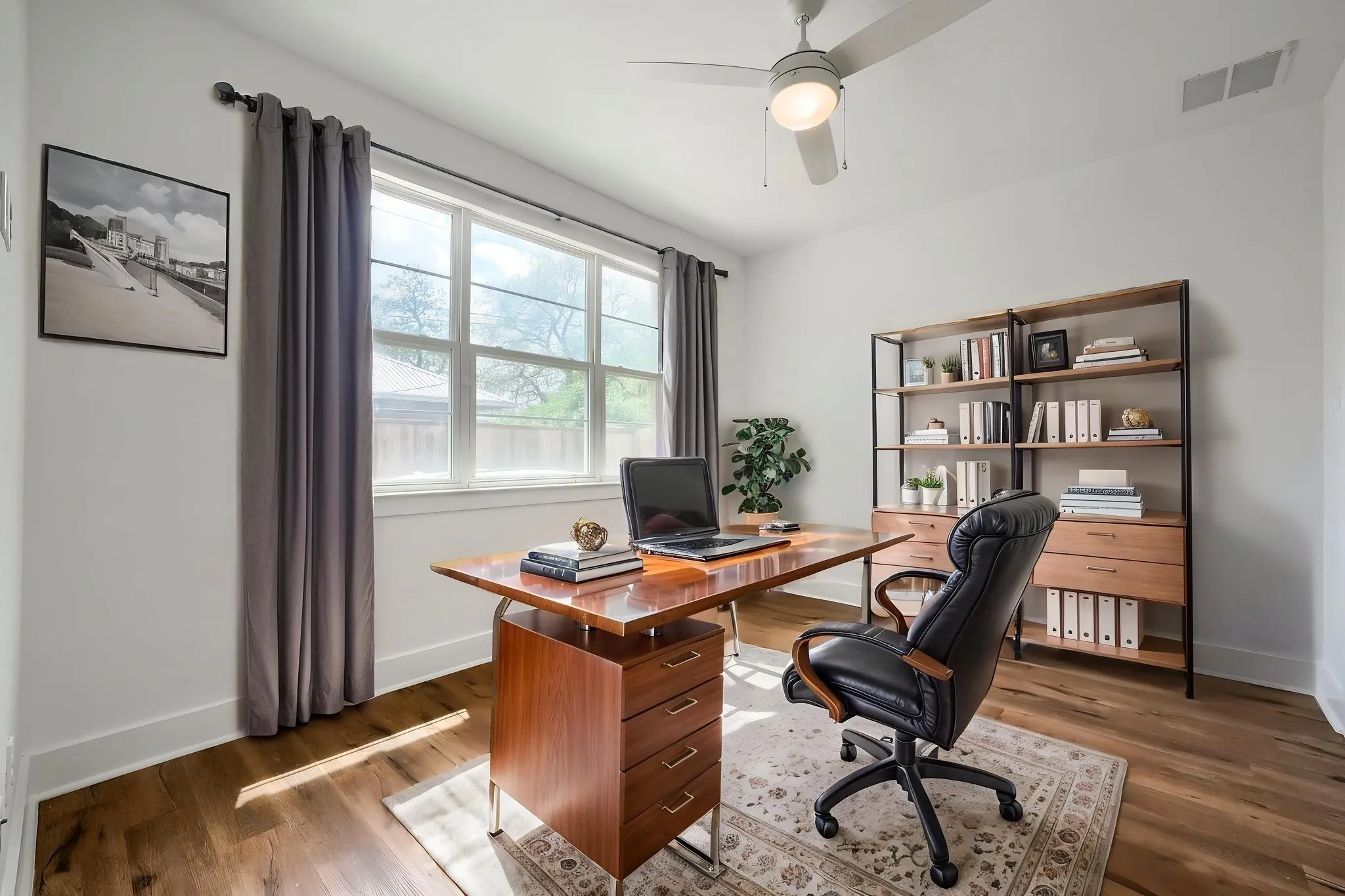 Wood-finish flooring, built-in shelving, ceiling fan with light fixture, and multiple windows