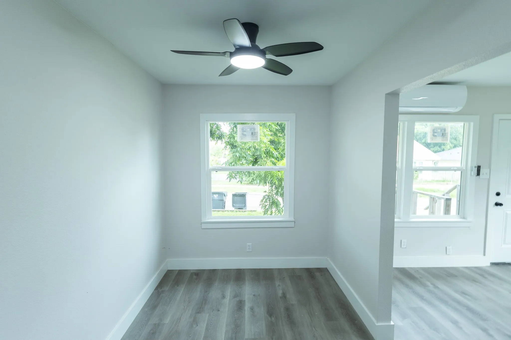 Recessed lighting, wood-finish flooring, ceiling fan, white trim, and a window unit
