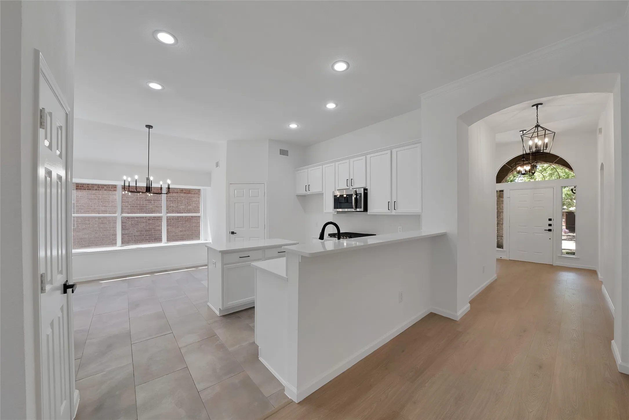 Light and bright kitchen offers an abundance of cabinetry and sleek quartz countertops.