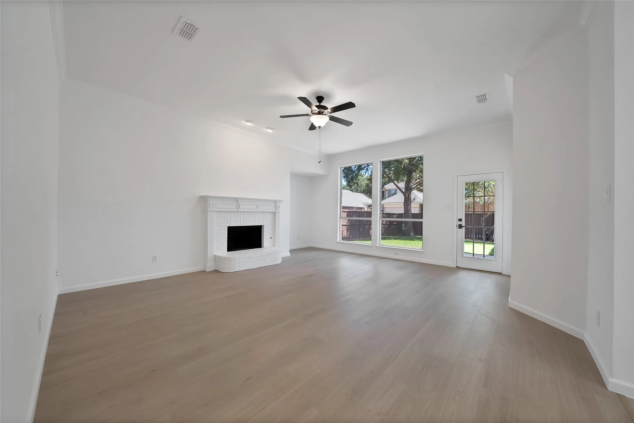 Large living room boasts a gas starter fireplace and large windows overlooking the good size backyard.