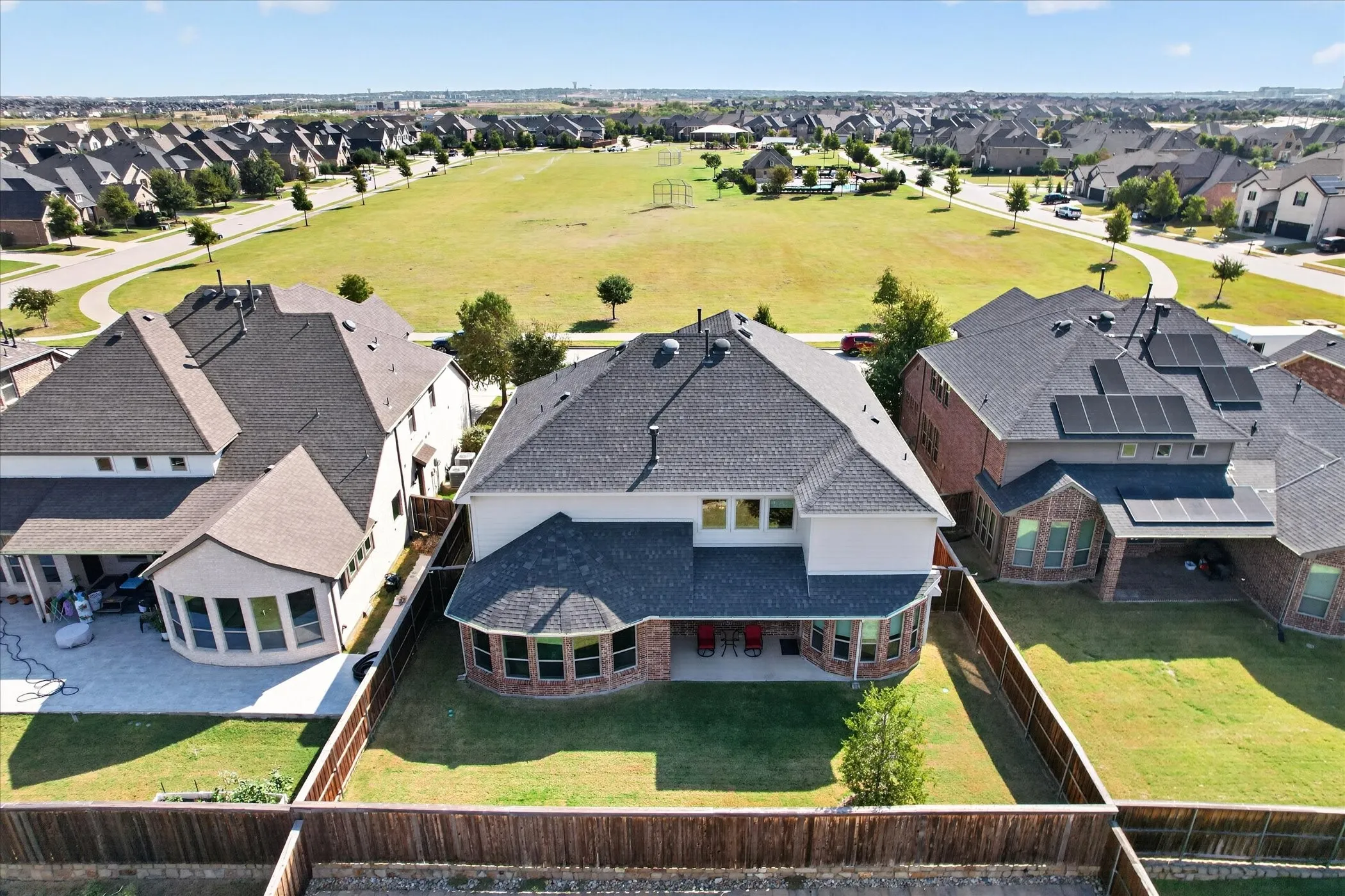 Two-story residence featuring a covered patio, fenced backyard, and a brick and siding exterior