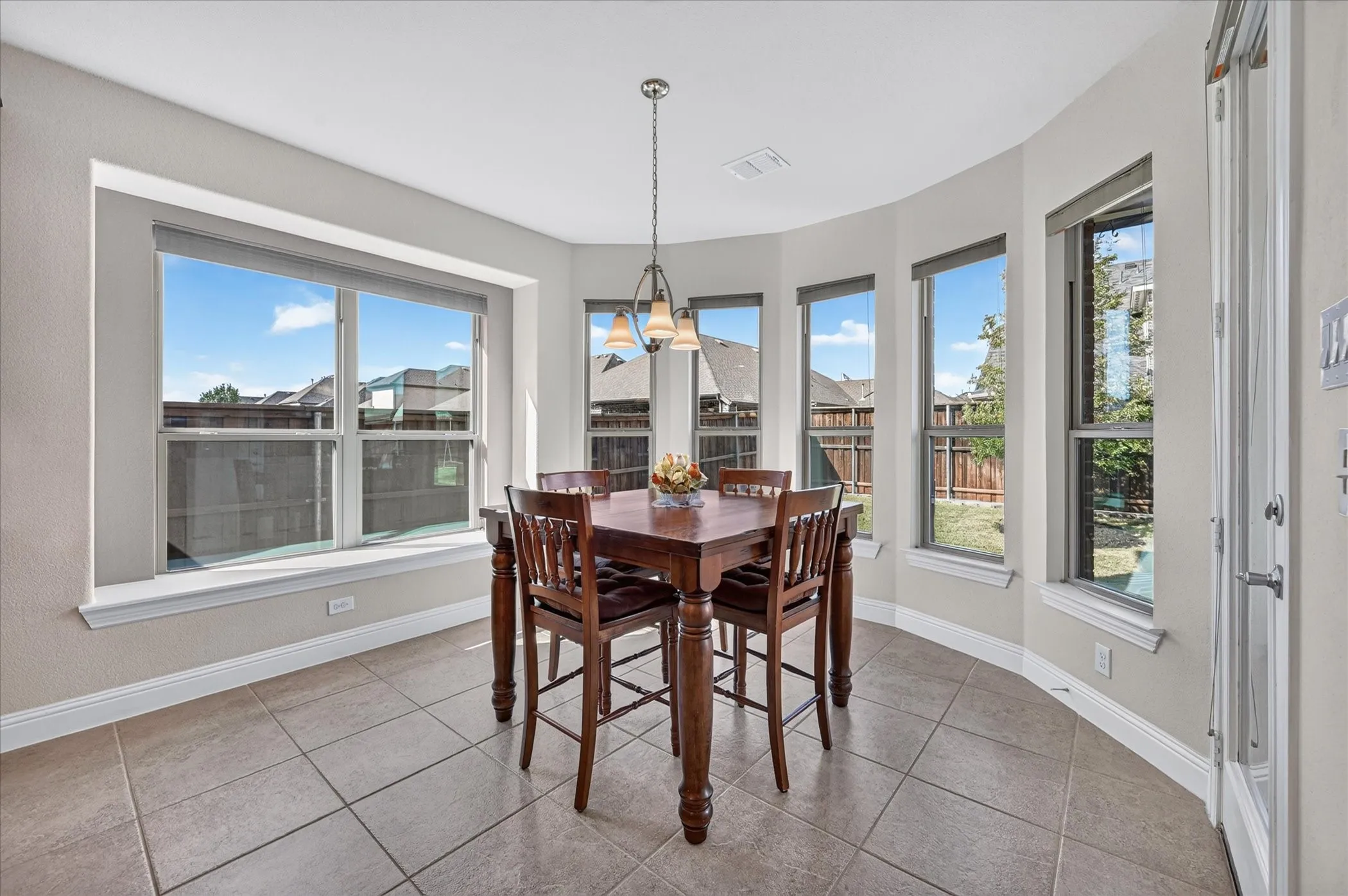 Bay window area with ceramic tile flooring and a multi-light chandelier