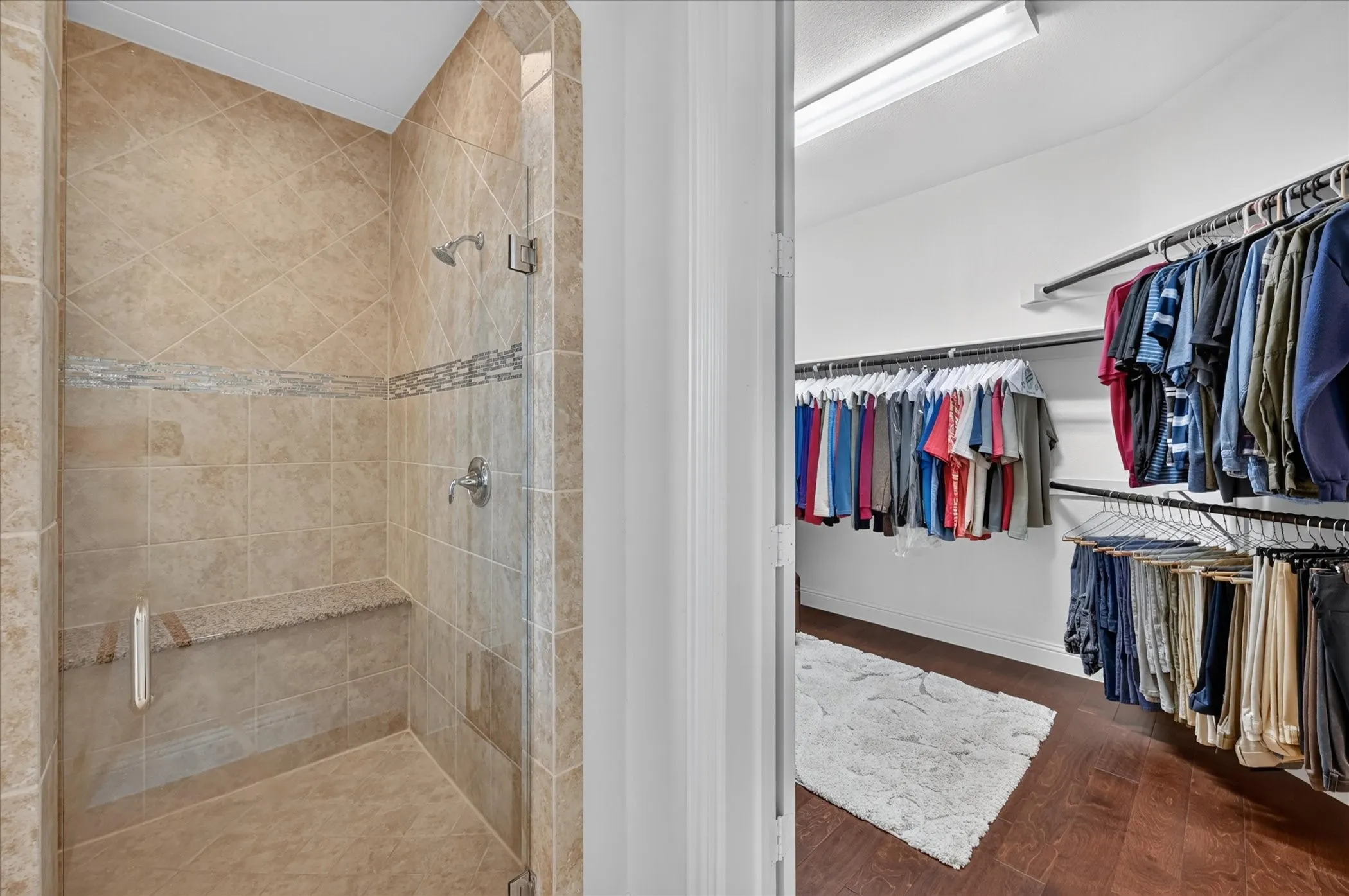 Shower with tiled walls, integrated bench, and mosaic accent band
