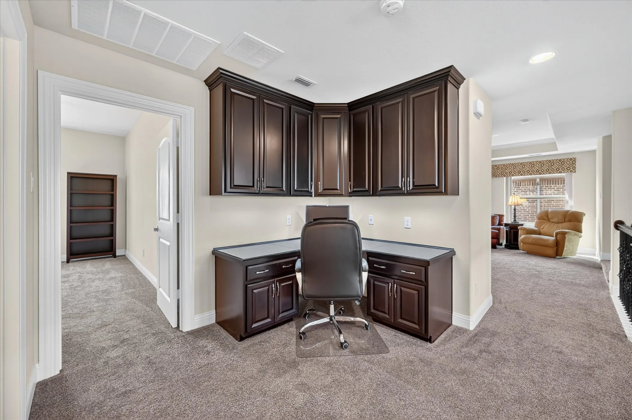 Built-in desk area with dark wood-finish cabinetry and gray countertop