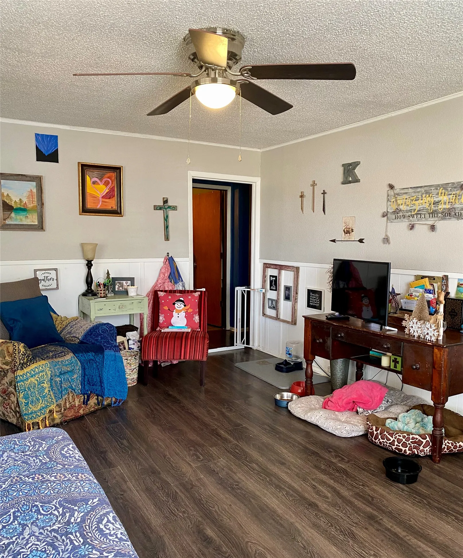 Living room currently set up as a bedroom, dark wood finished floors, and washing machine and clothes dryer