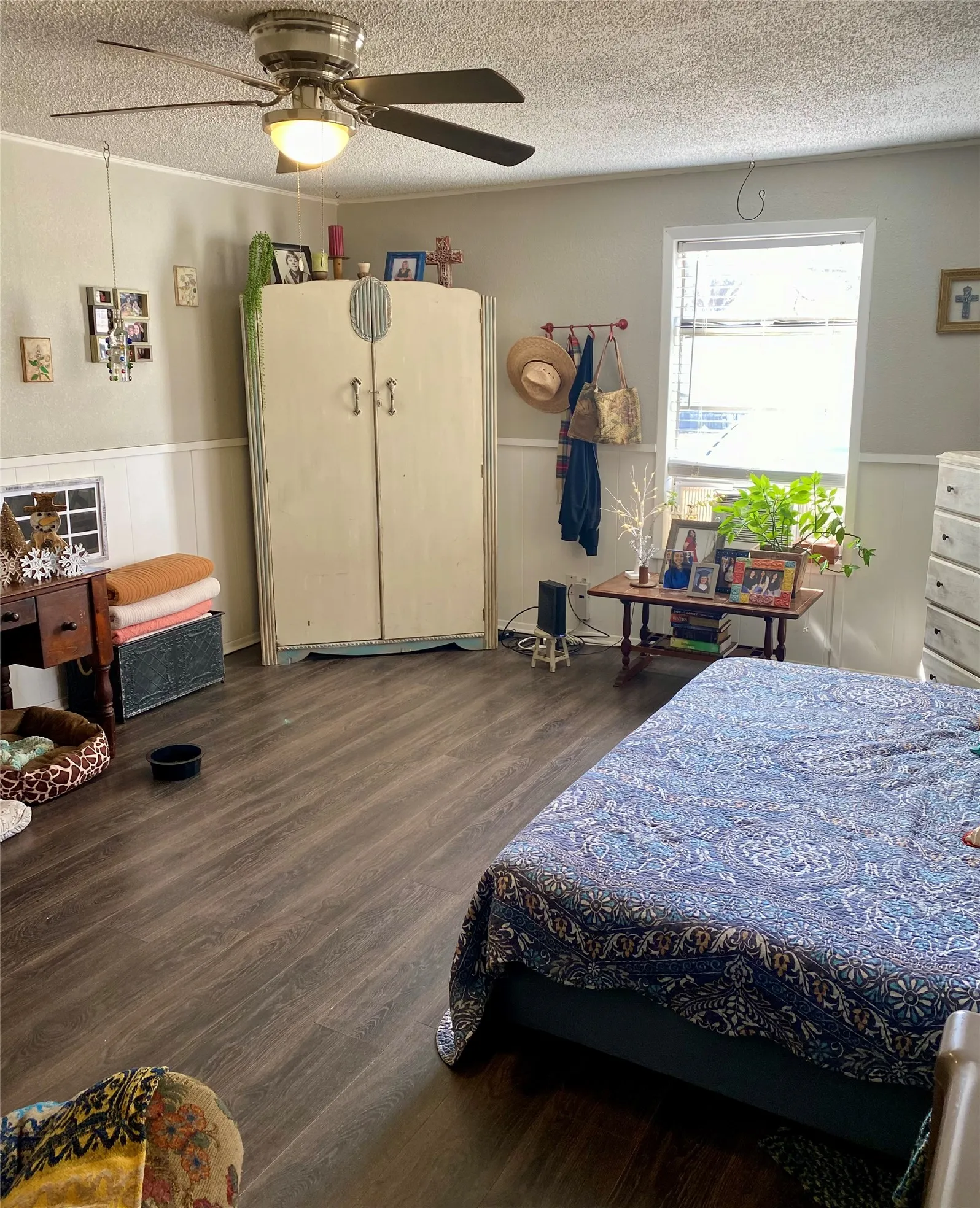 Living room currently set up as a bedroom with wood finished floors and vanity