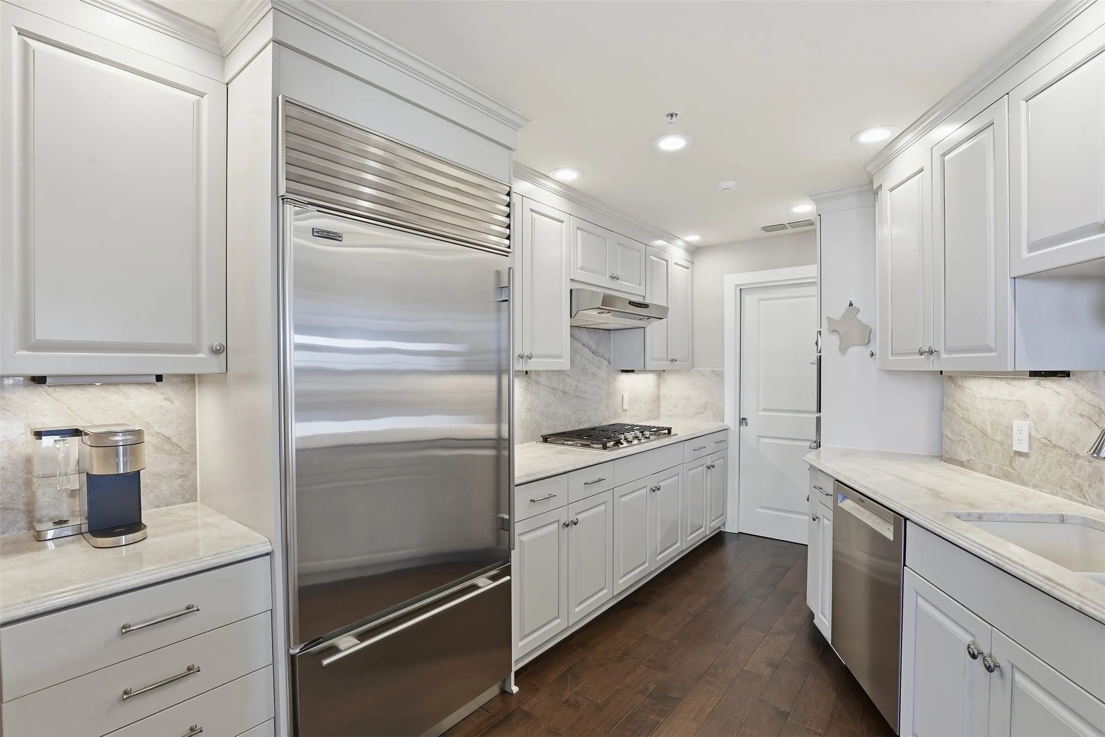 White cabinetry with crown molding, stainless steel appliances, stone countertops, and wood-finish flooring