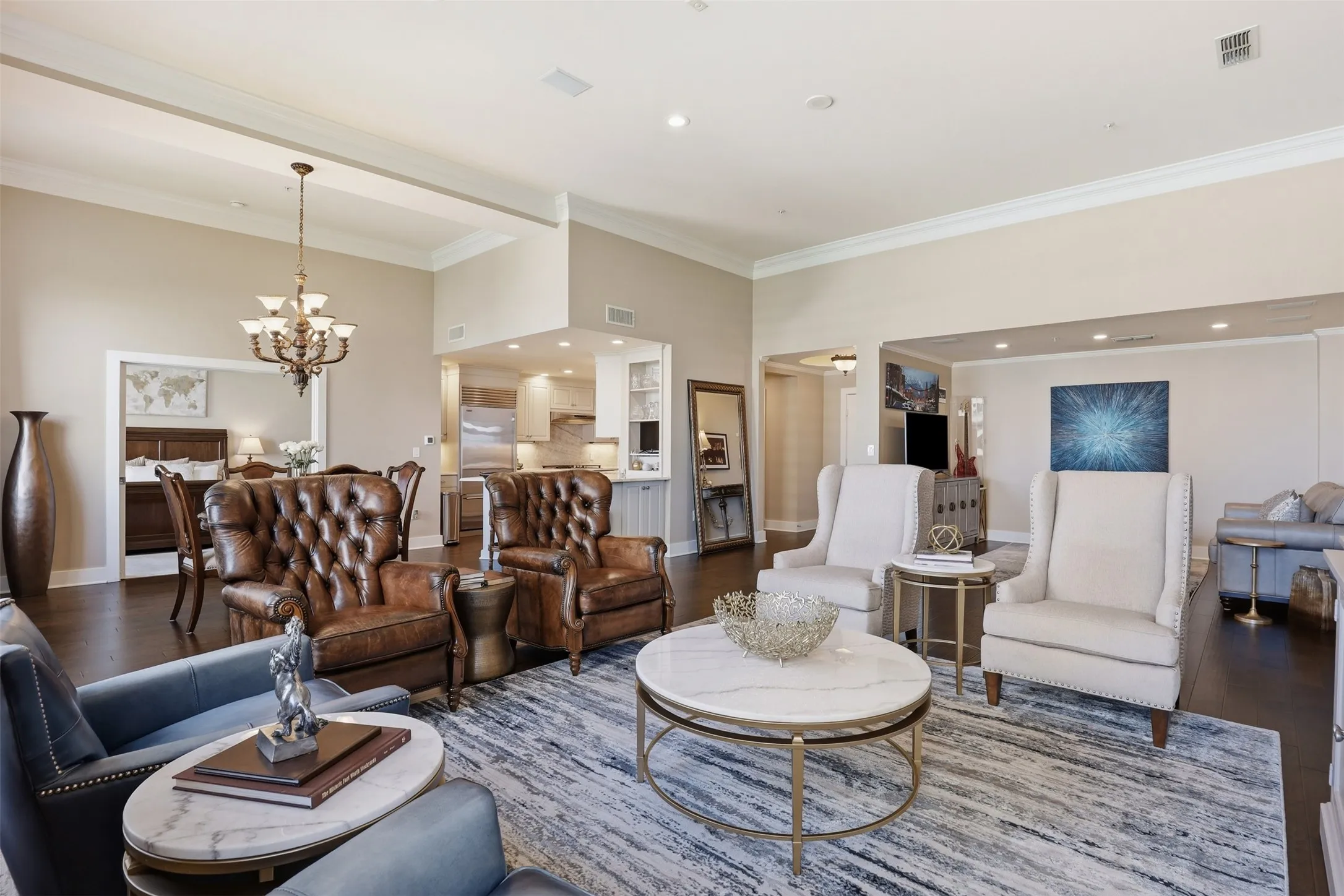Expansive open-concept living area featuring dark wood-finish flooring, high ceilings with crown molding, and recessed lighting