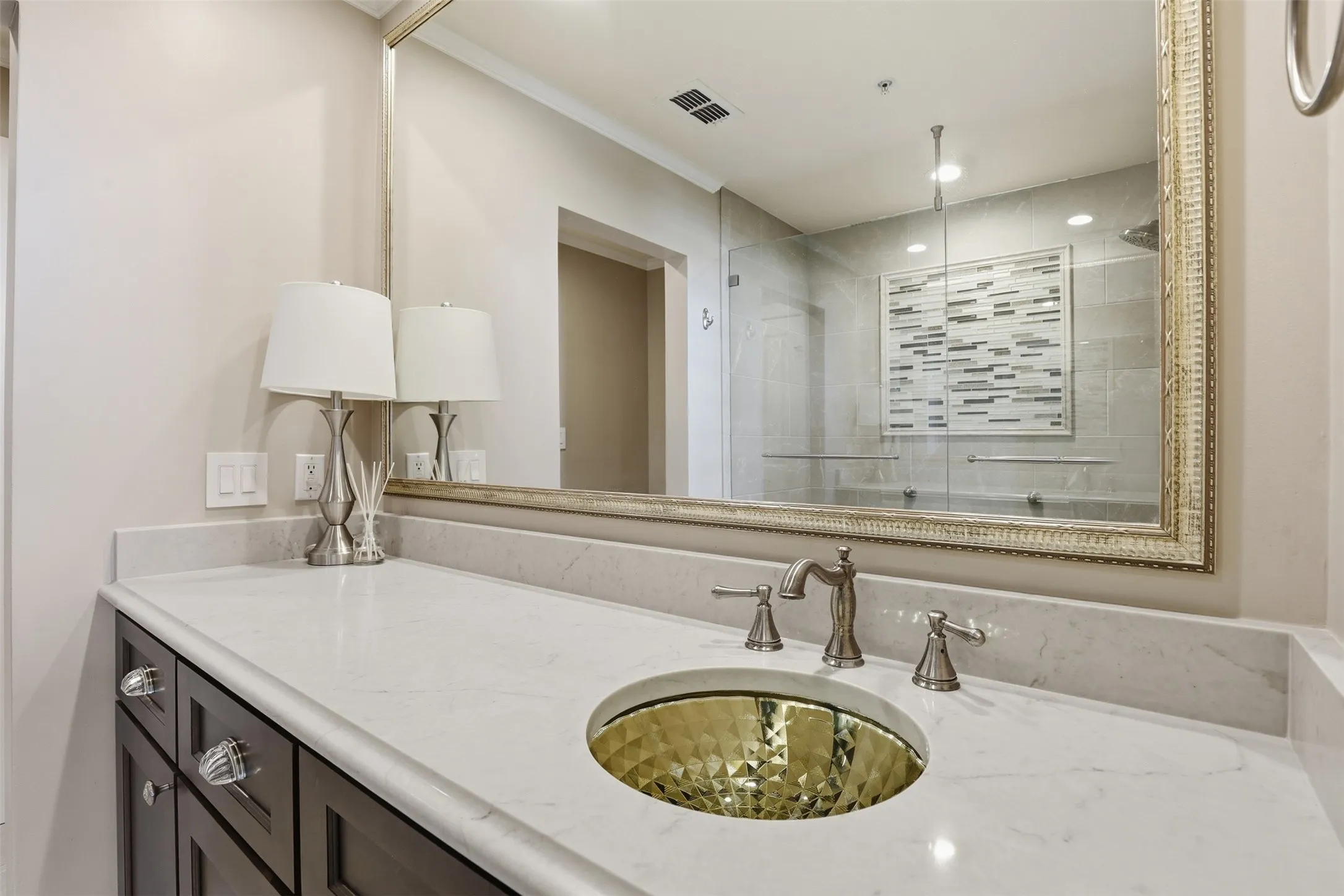 Dark wood-finish vanity with crystal knobs and pulls, featuring a white countertop with an integrated backsplash