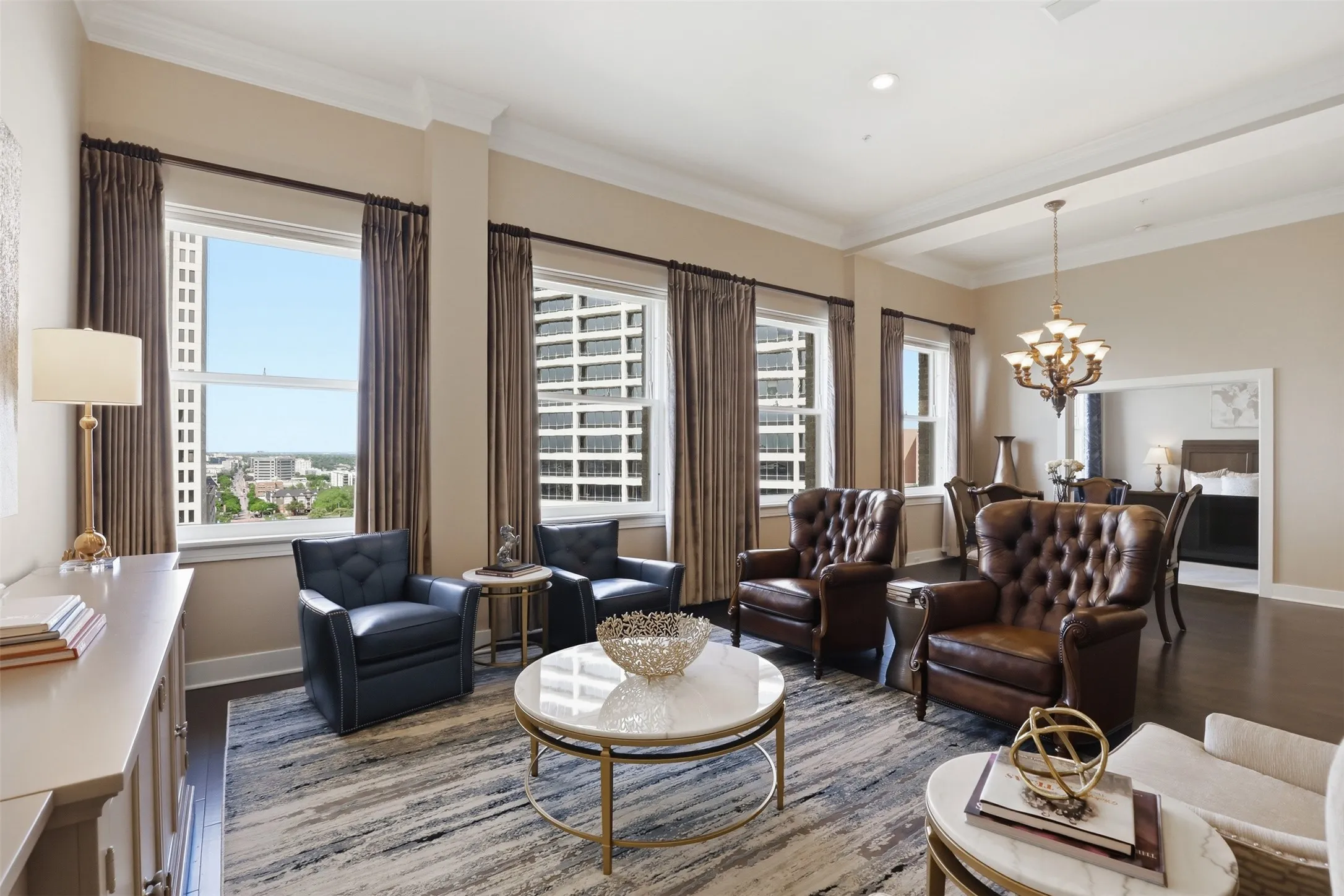 Hardwood-finish flooring, high ceilings with crown molding, multiple large windows, and a coffered ceiling detail