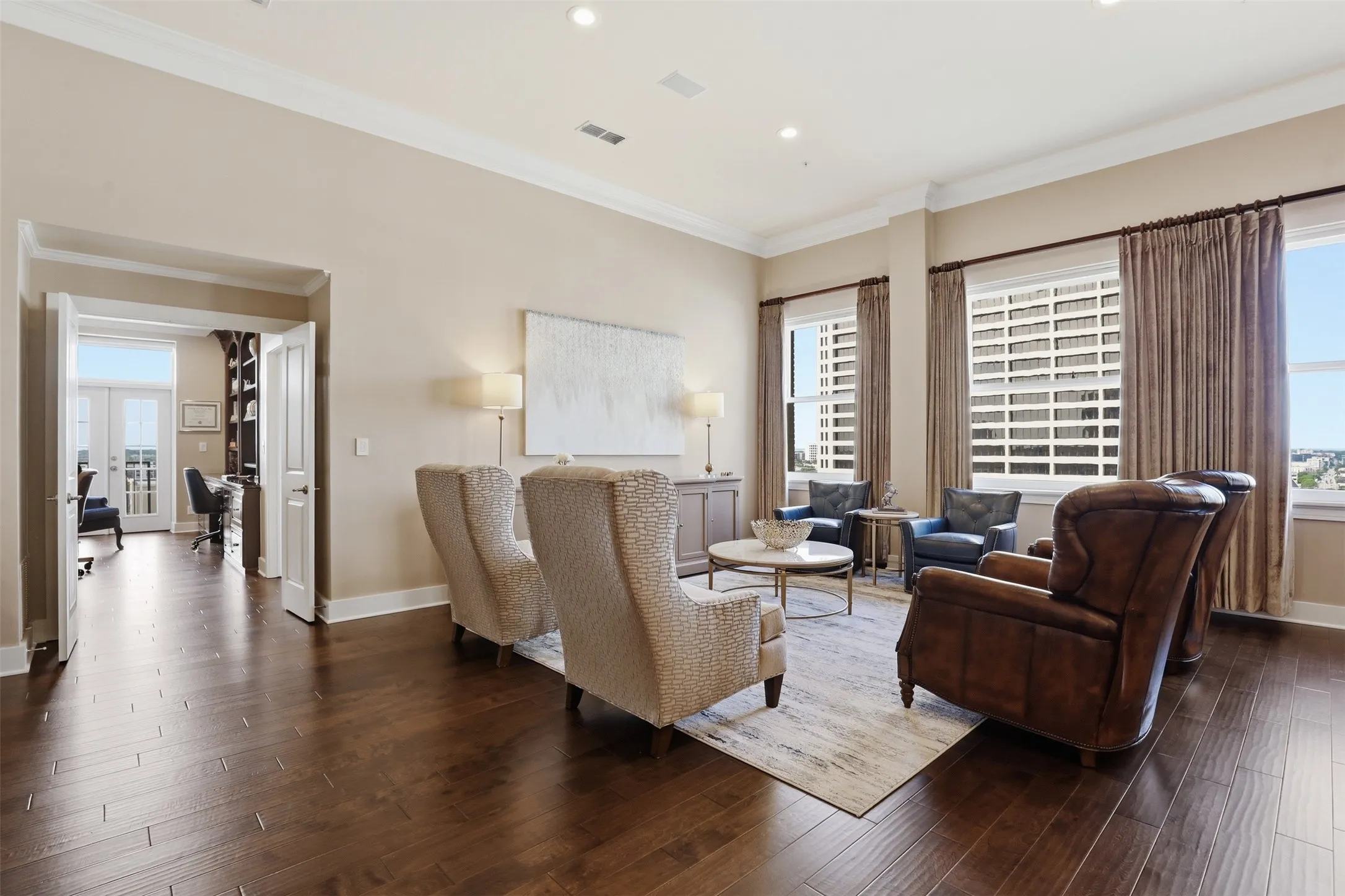 Spacious living area featuring wood-finish flooring, recessed lighting, and crown molding