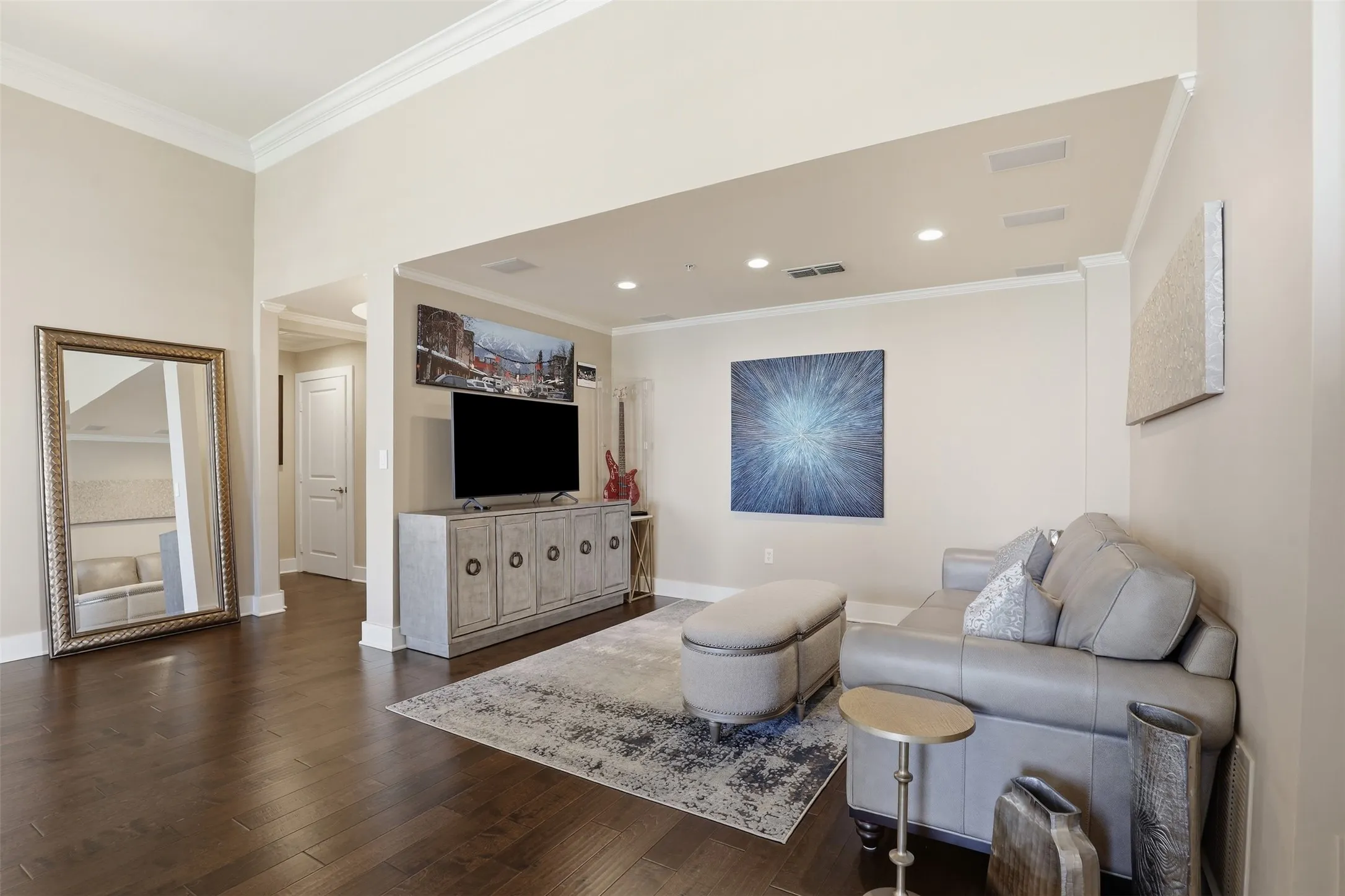 High ceilings, dark wood-finish flooring, crown molding, recessed lighting, and a neutral color palette