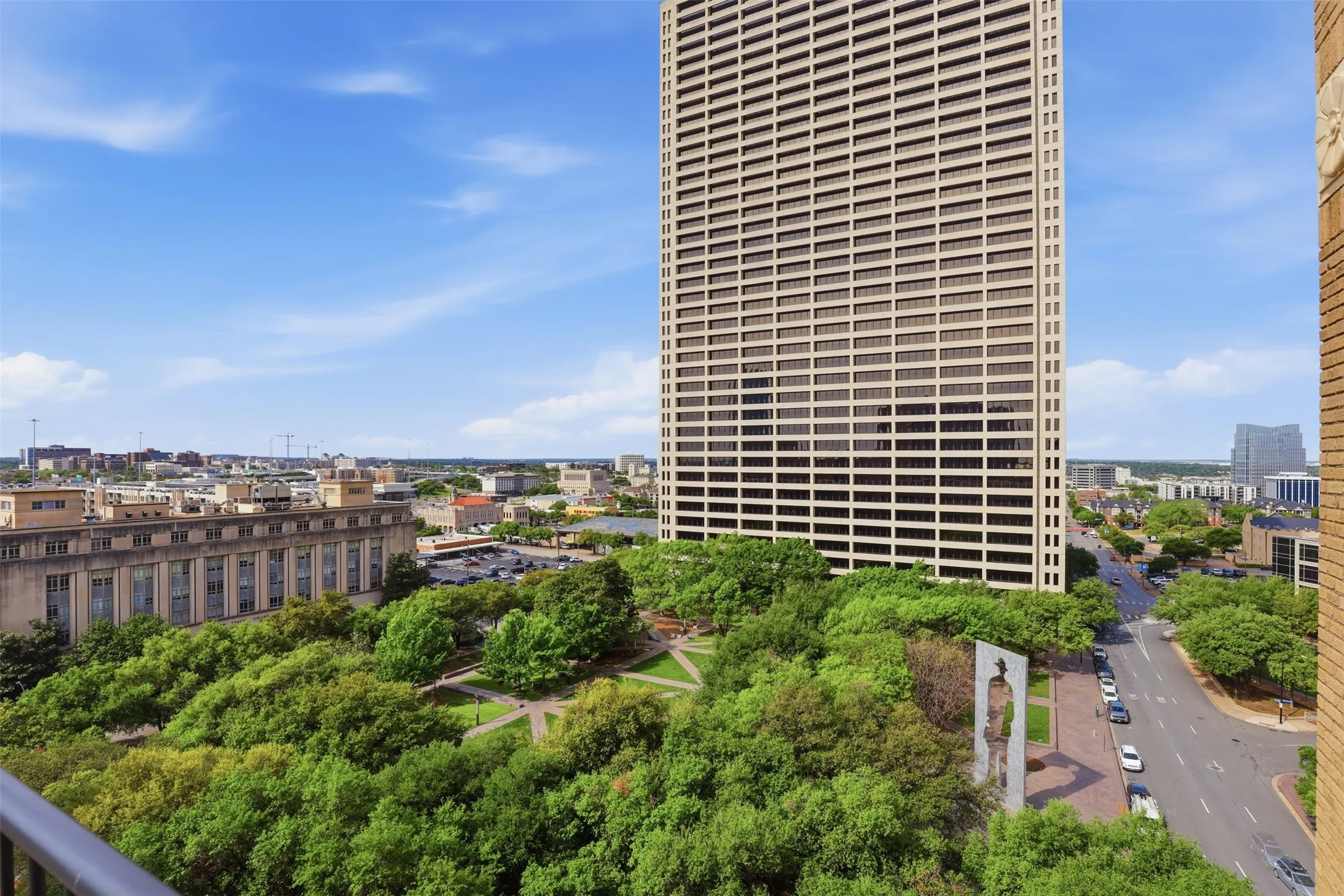Expansive urban view of Burnett Park with mature trees and paved pathways