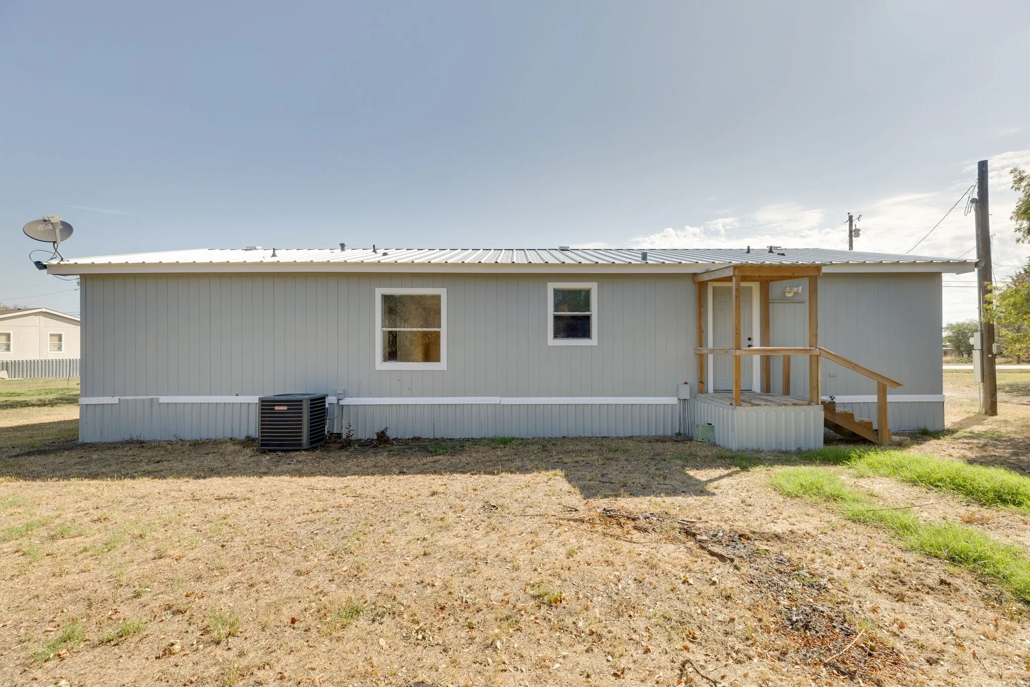 Light grey siding exterior with a metal roof