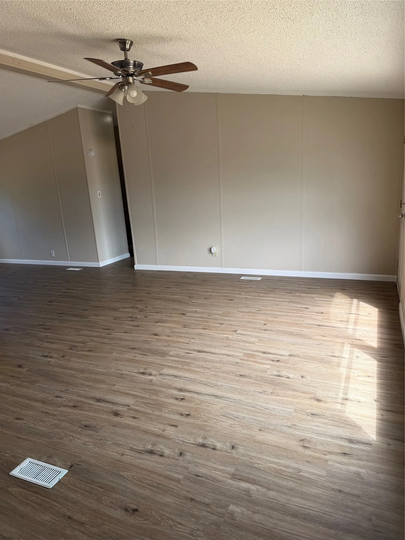 Wood-finish flooring throughout, complemented by light-toned wall paneling