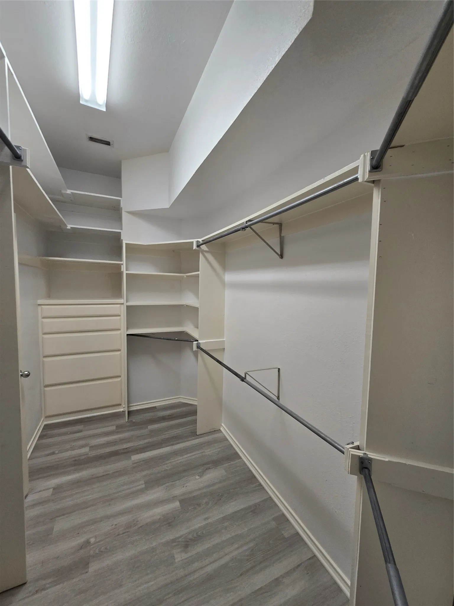 Custom closet system featuring built-in shelving, integrated drawers, and multiple hanging rods