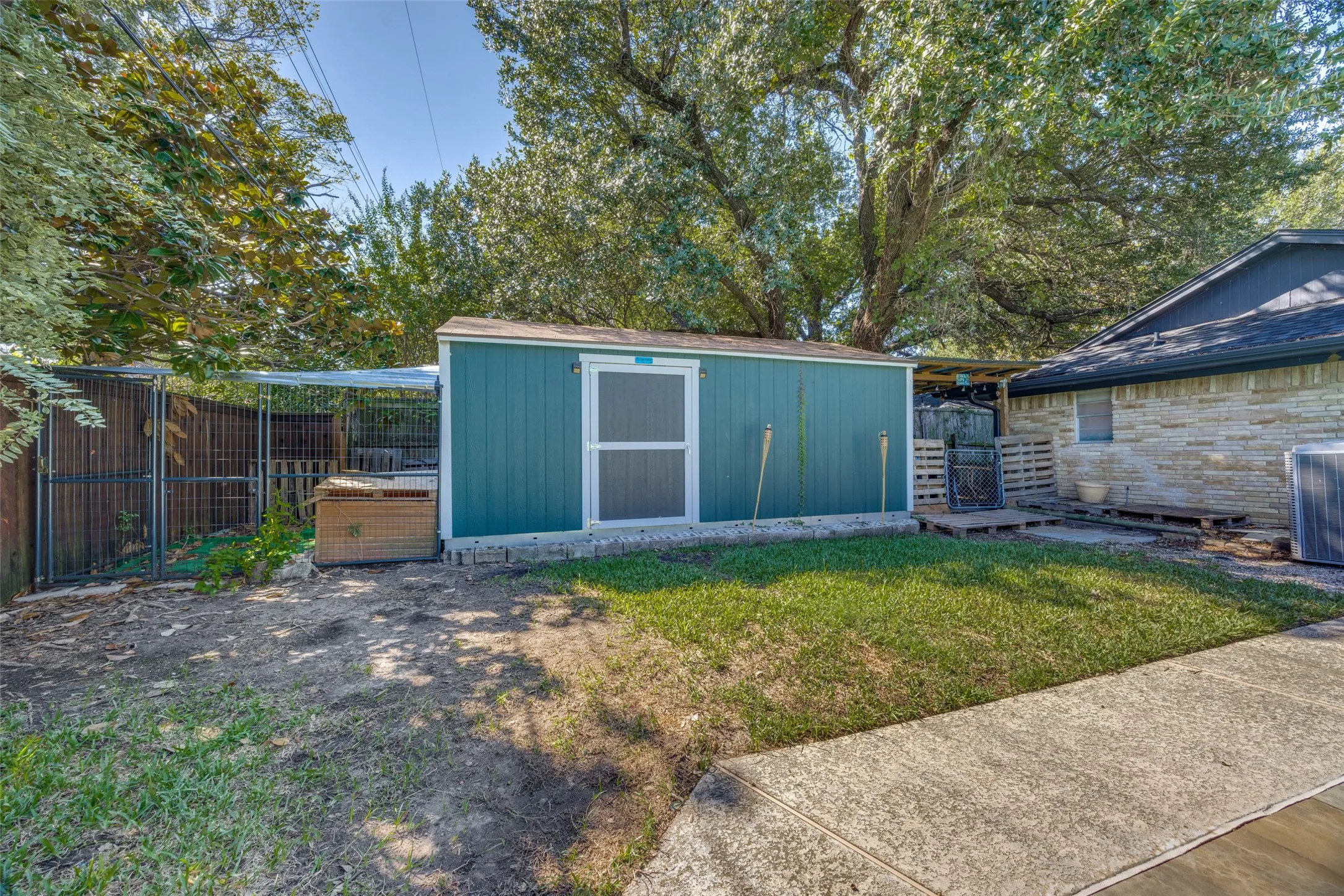 Backyard featuring a detached storage shed, privacy fencing, and a concrete walkway