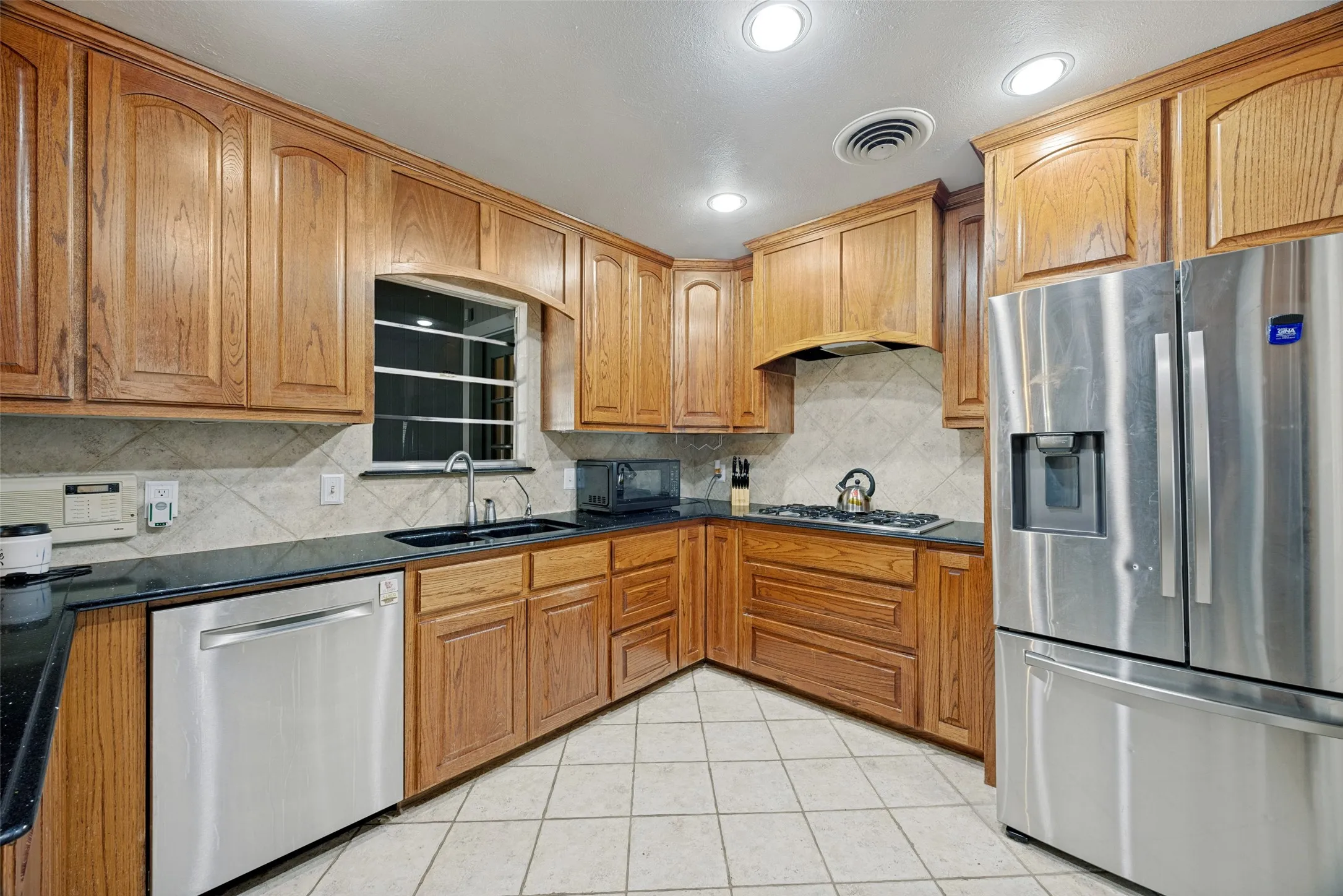 Wood-finish cabinetry with dark countertops