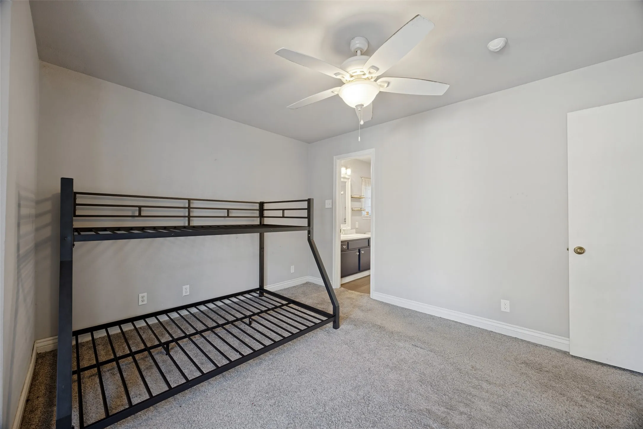 Wall-to-wall carpeting and a ceiling fan with integrated lighting