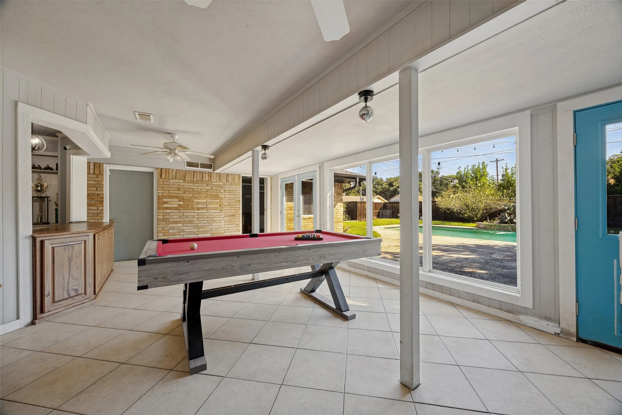 Spacious room with tile flooring, built-in bar, and extensive window-frontage