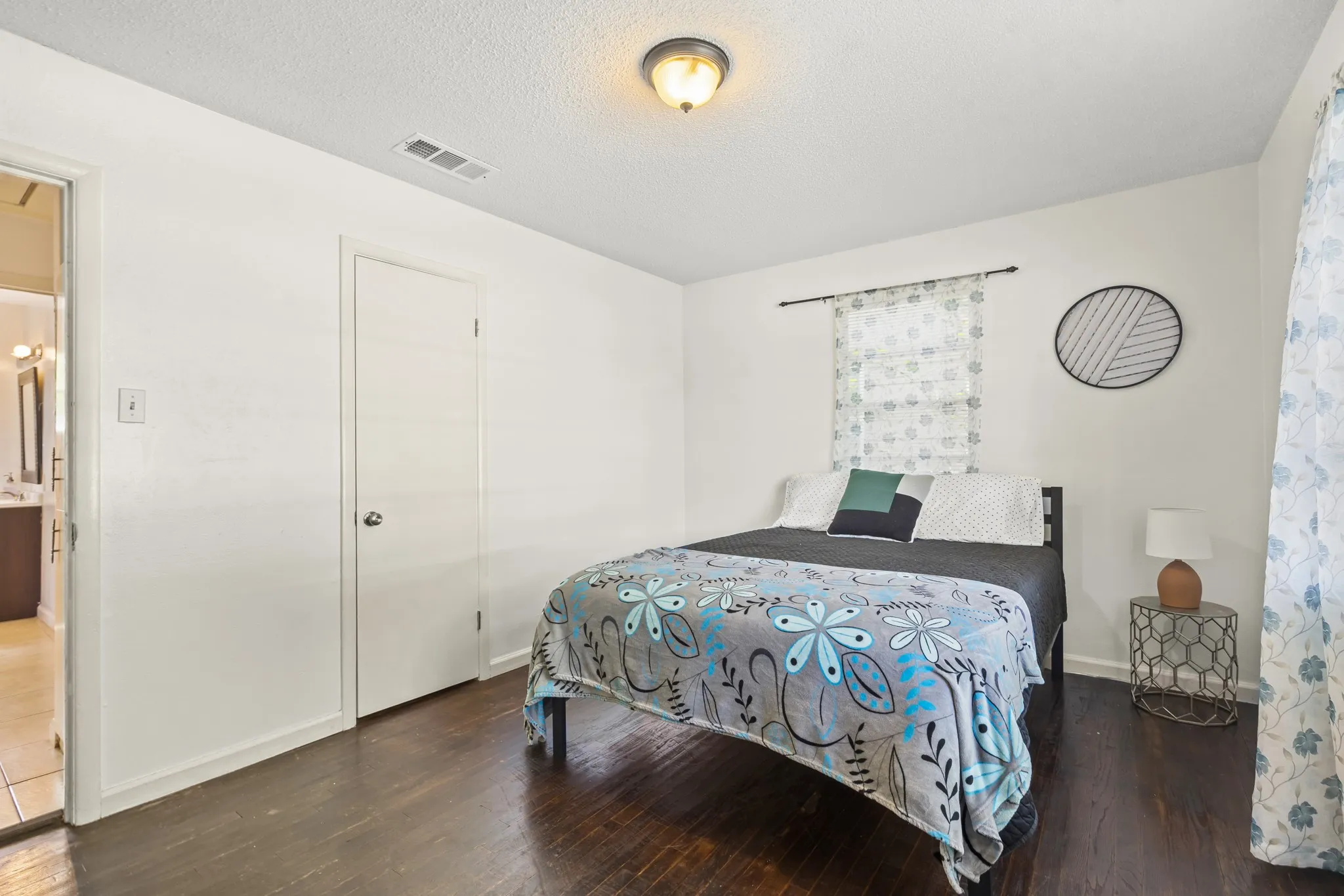 Hardwood-finish flooring, white painted walls, and a window with natural light