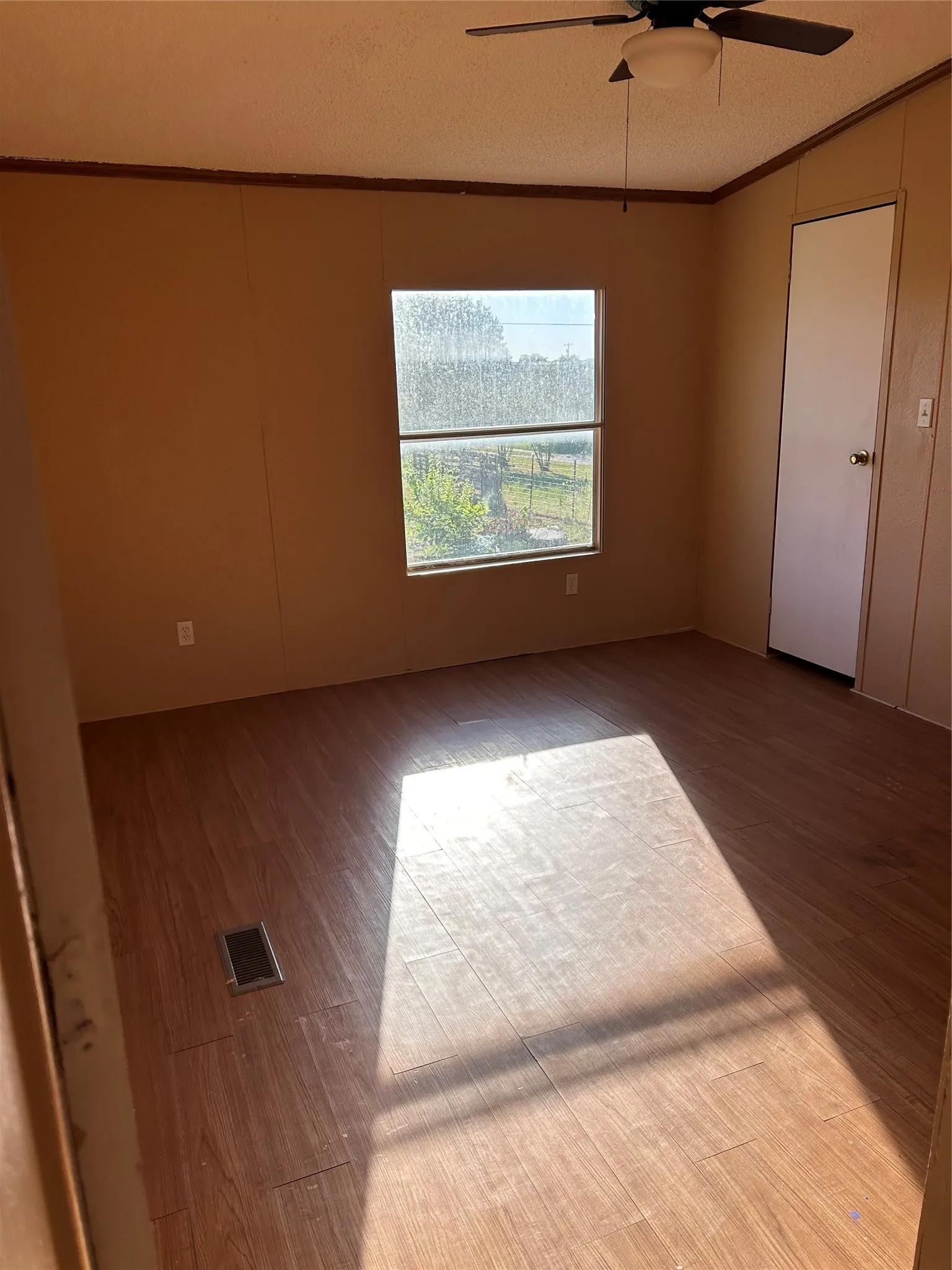 Wood-finish flooring, ceiling fan, and a neutral wall palette