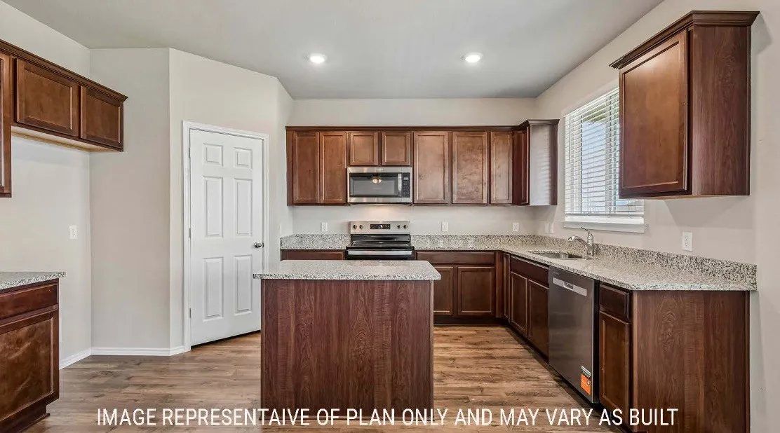 Kitchen featuring wood-finish cabinetry, granite-finish countertops, stainless steel appliances, a center island, and wood-finish flooring