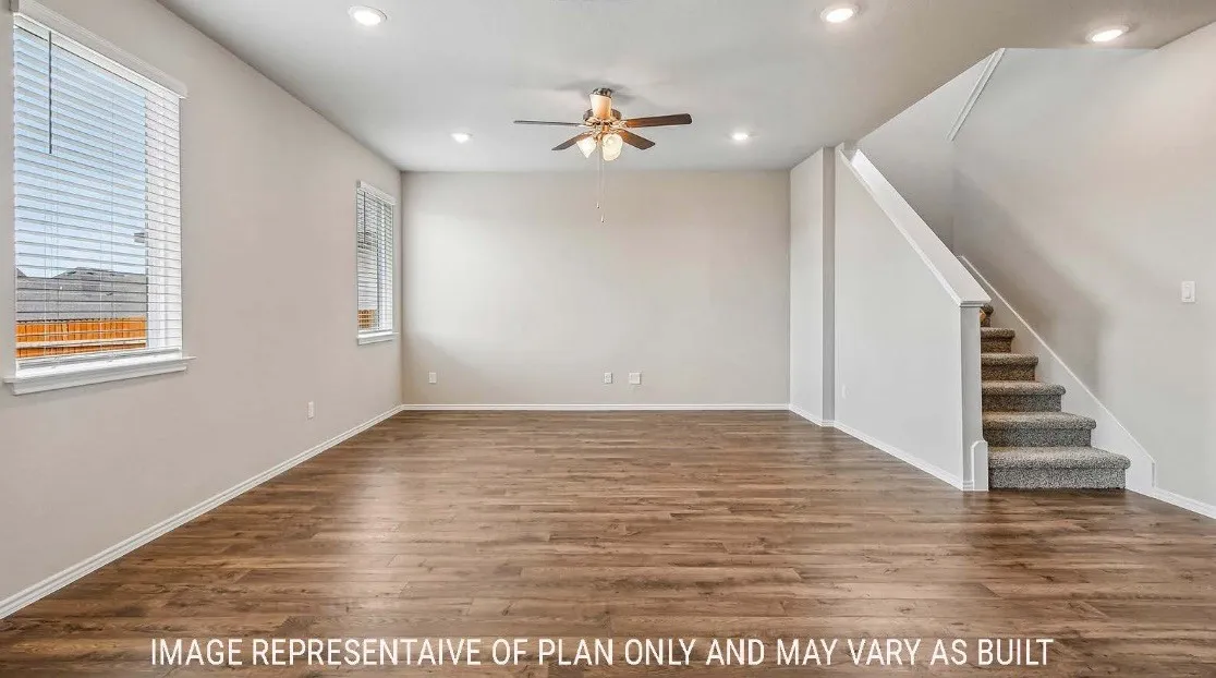 Spacious room with wood-finish flooring, recessed lighting, and a ceiling fan