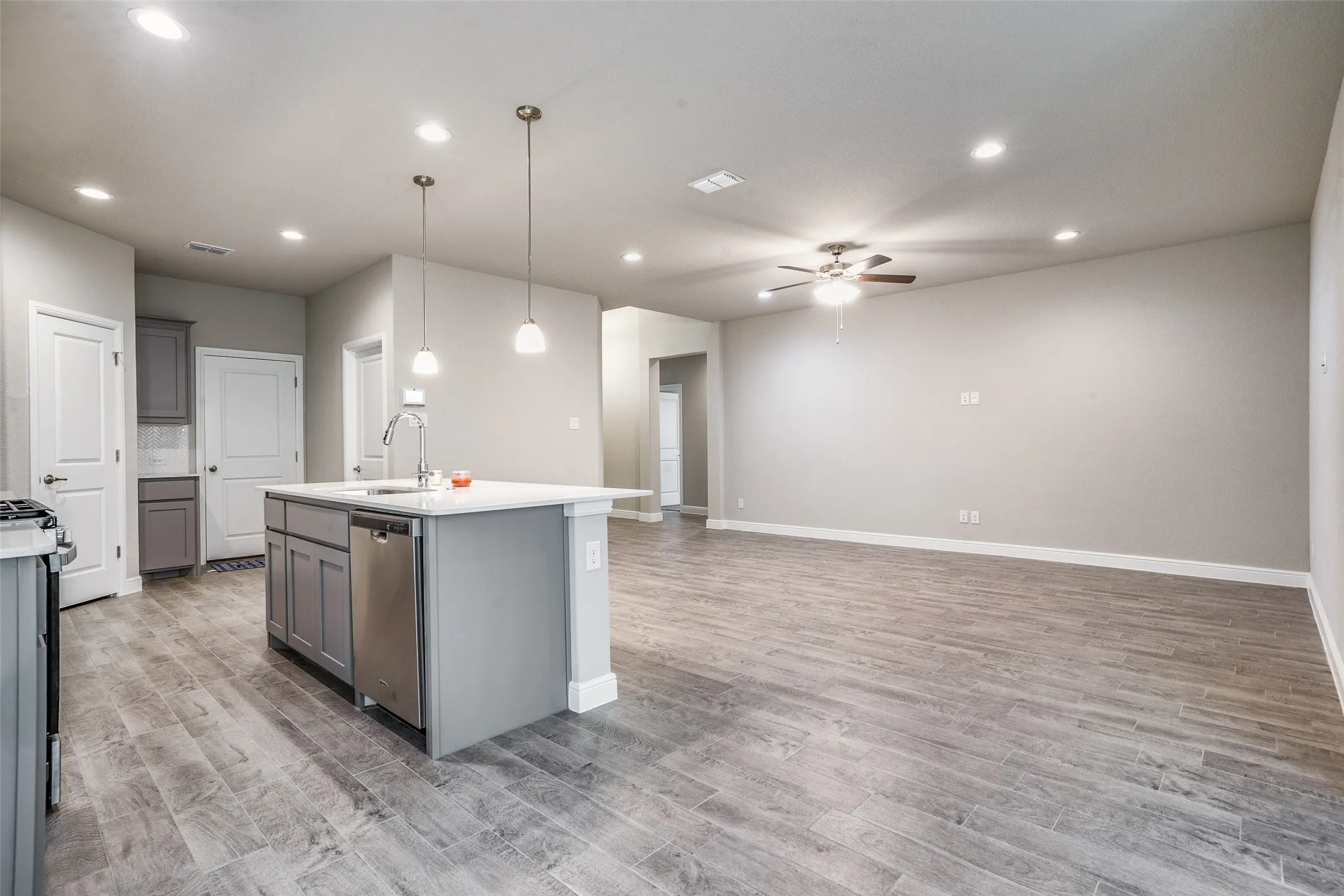 Open-concept living space featuring wood-finish flooring, recessed lighting, and a ceiling fan