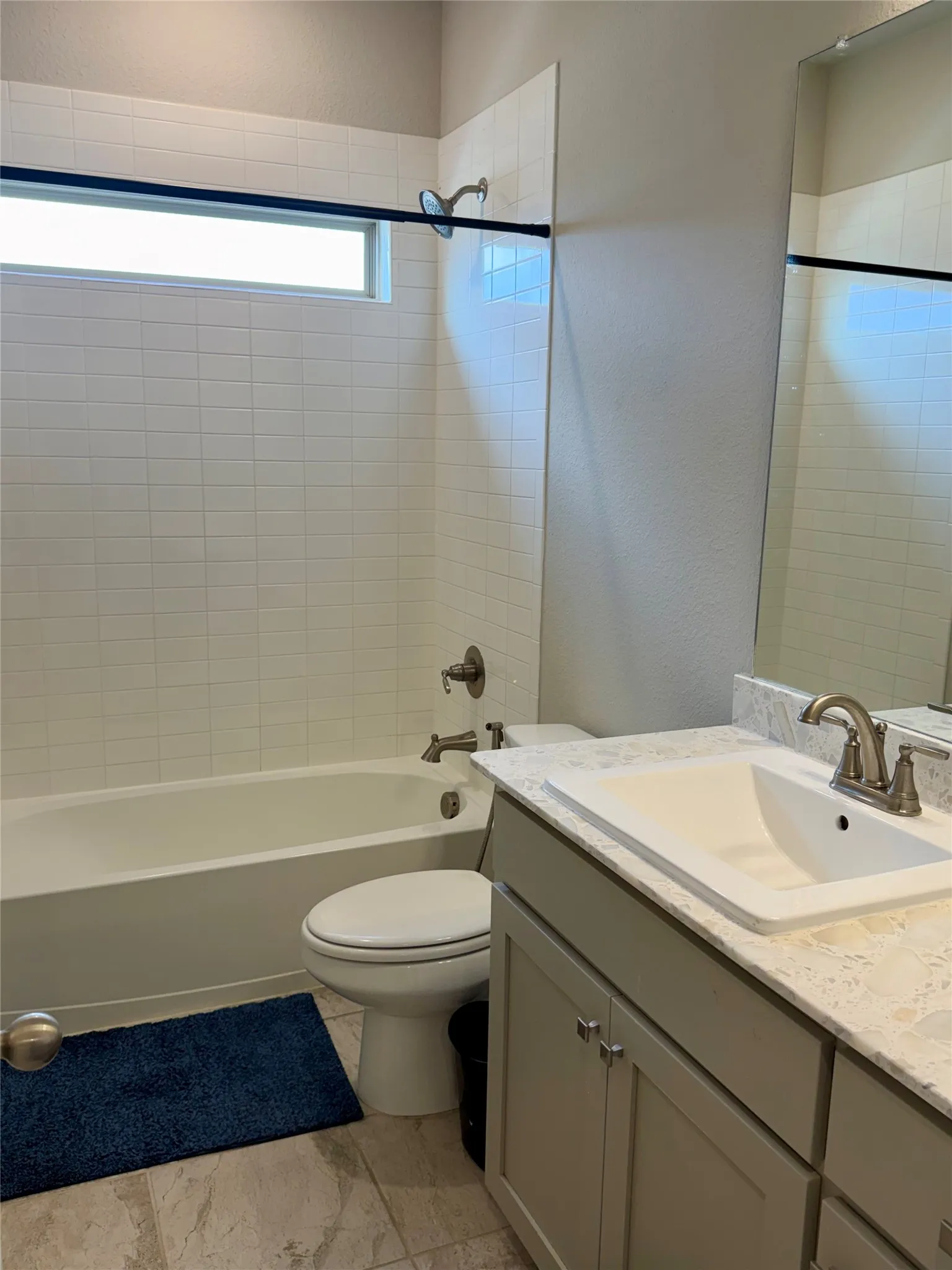 Full bathroom featuring a vanity with an integrated sink, light-toned countertop, and undermount cabinetry