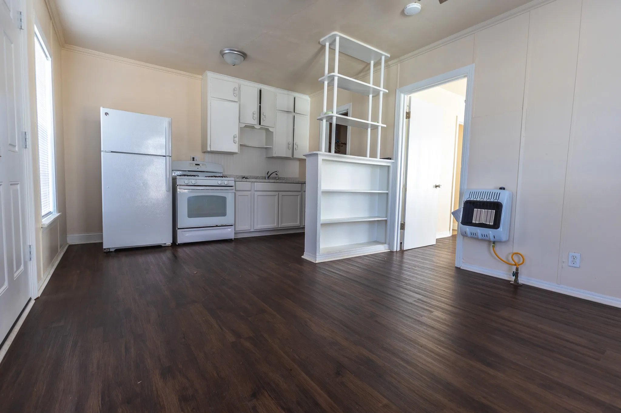 Kitchen featuring white cabinetry, a freestanding range, and a refrigerator