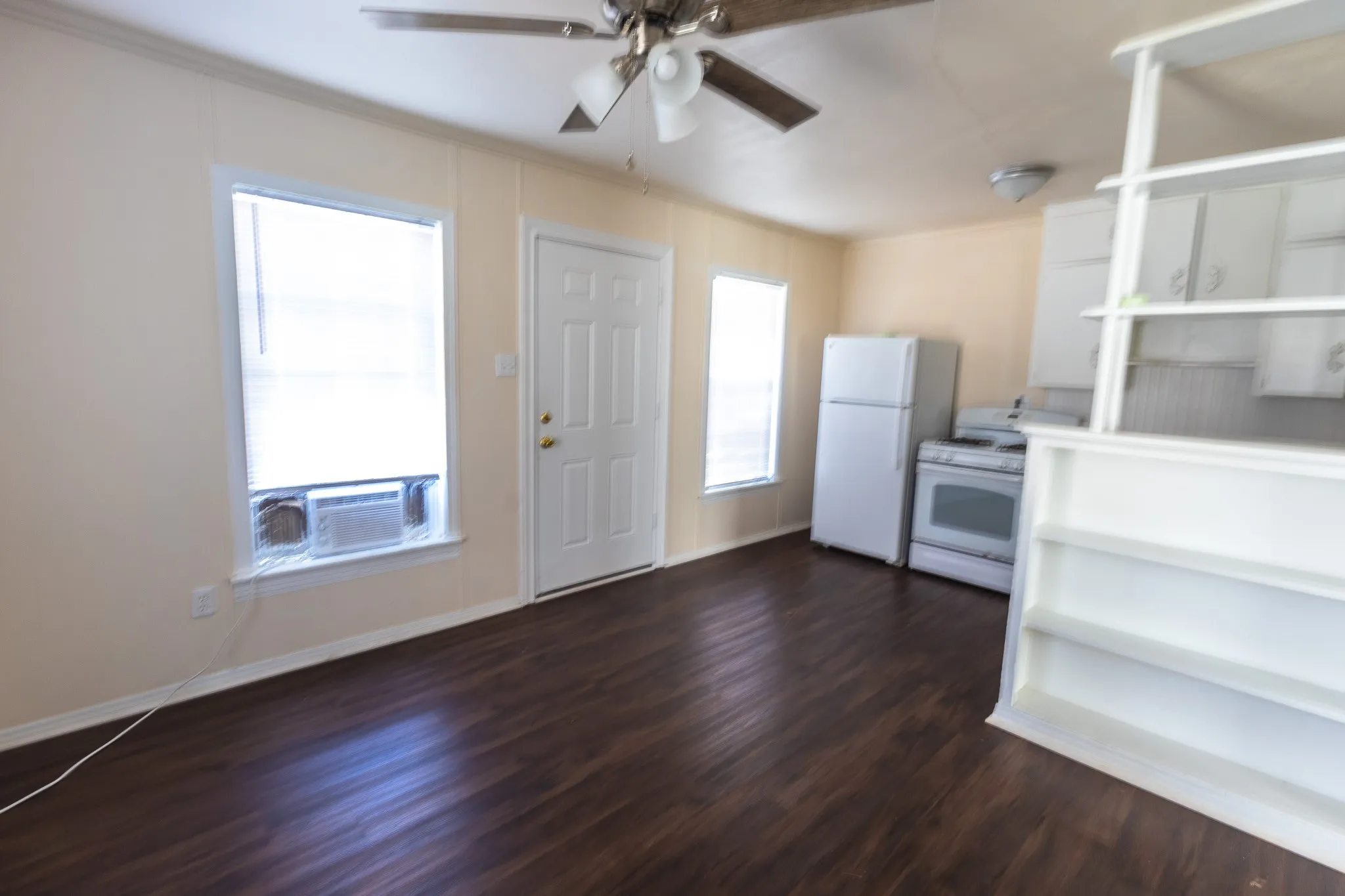 Wood-finish flooring throughout, complemented by a ceiling fan with integrated lighting