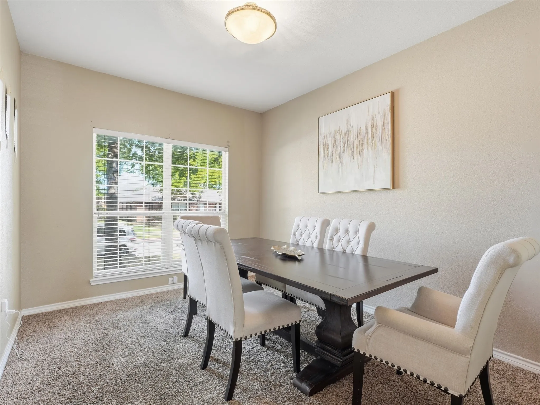 Recessed lighting and a single window with blinds illuminate this carpeted room, featuring neutral-toned walls