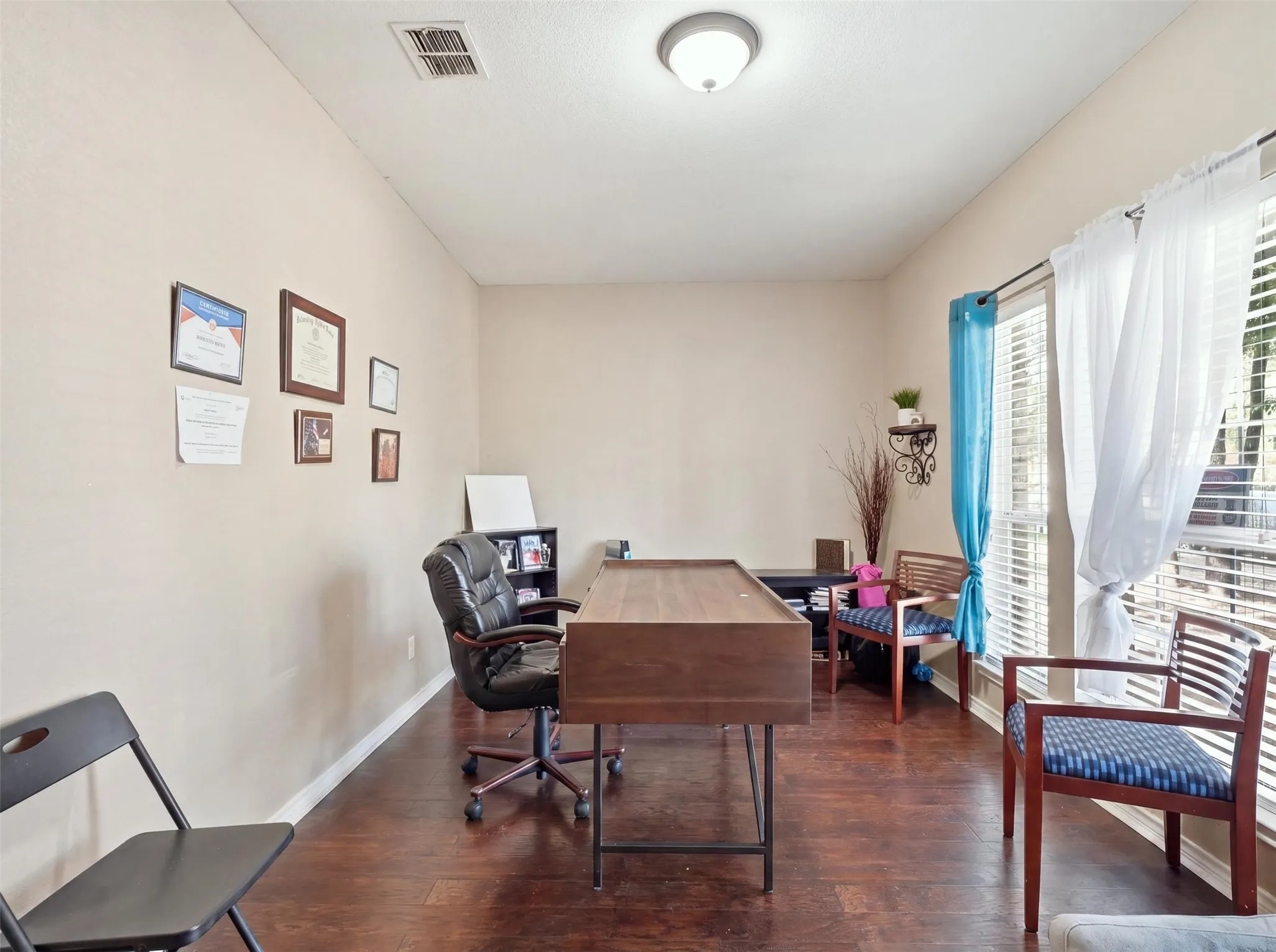 Wood-finish flooring with neutral wall tones and a ceiling-mounted light fixture