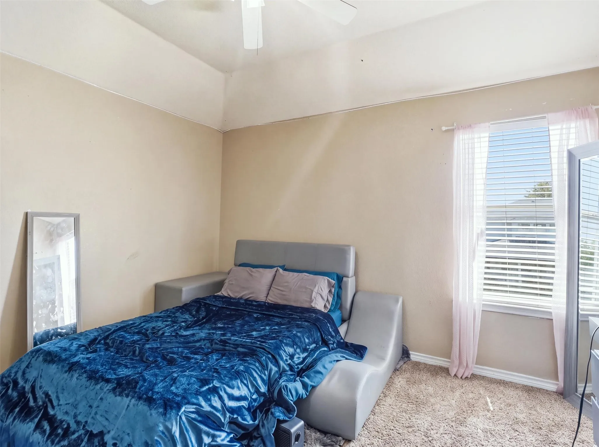 Carpeted room with a ceiling fan, a window with blinds, and painted walls