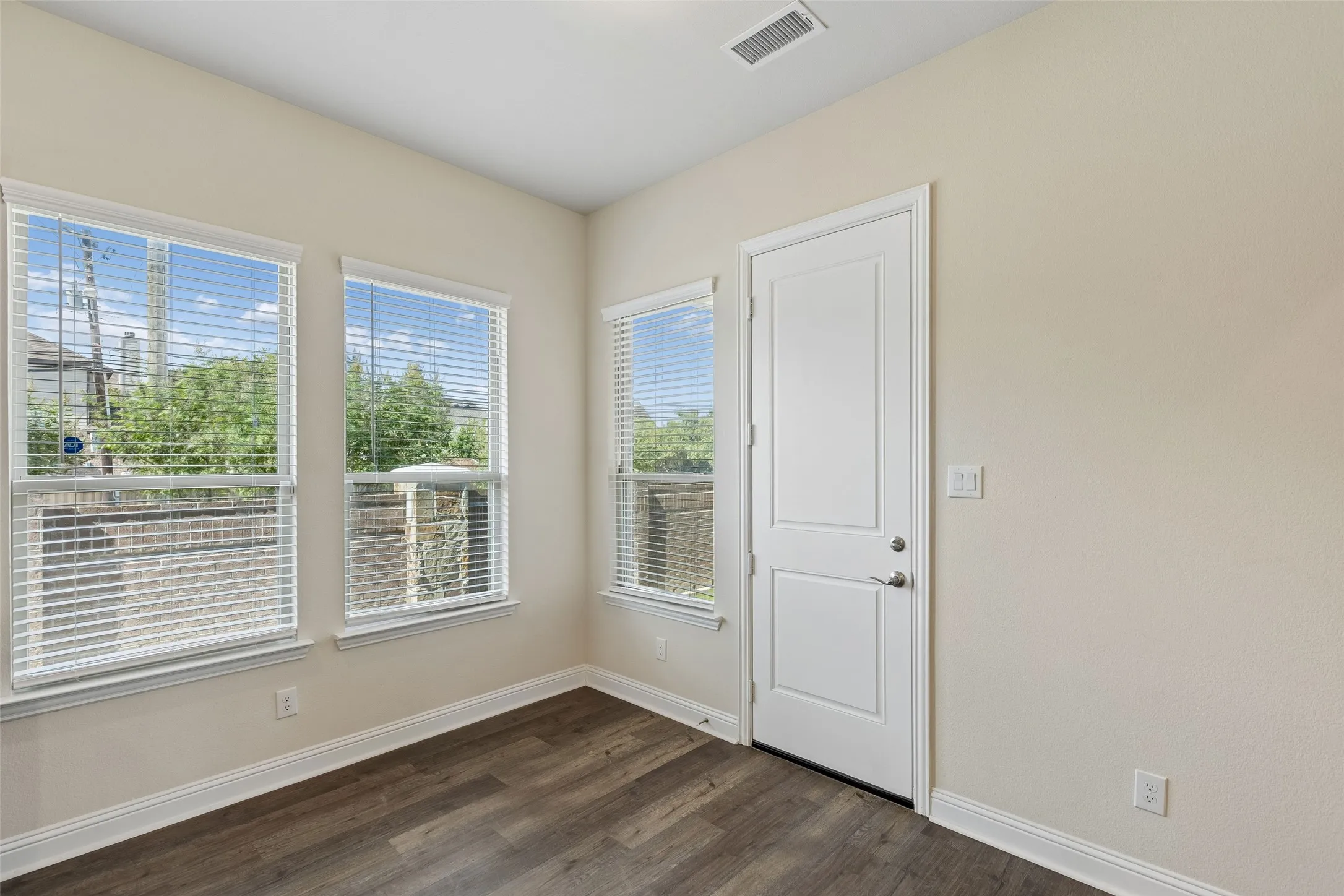 Dining area, eat in kitchen. Featuring LVP flooring and natural light. Door leads to back porch.