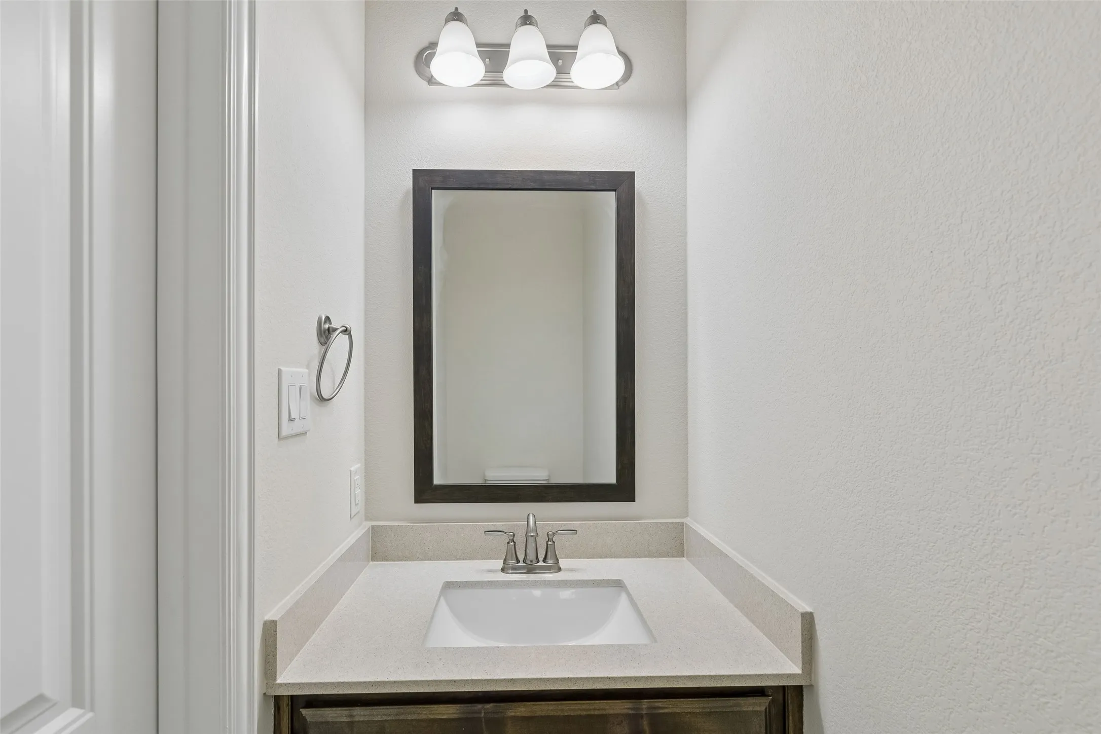 Half bathroom featuring silestone counters and cabinets.