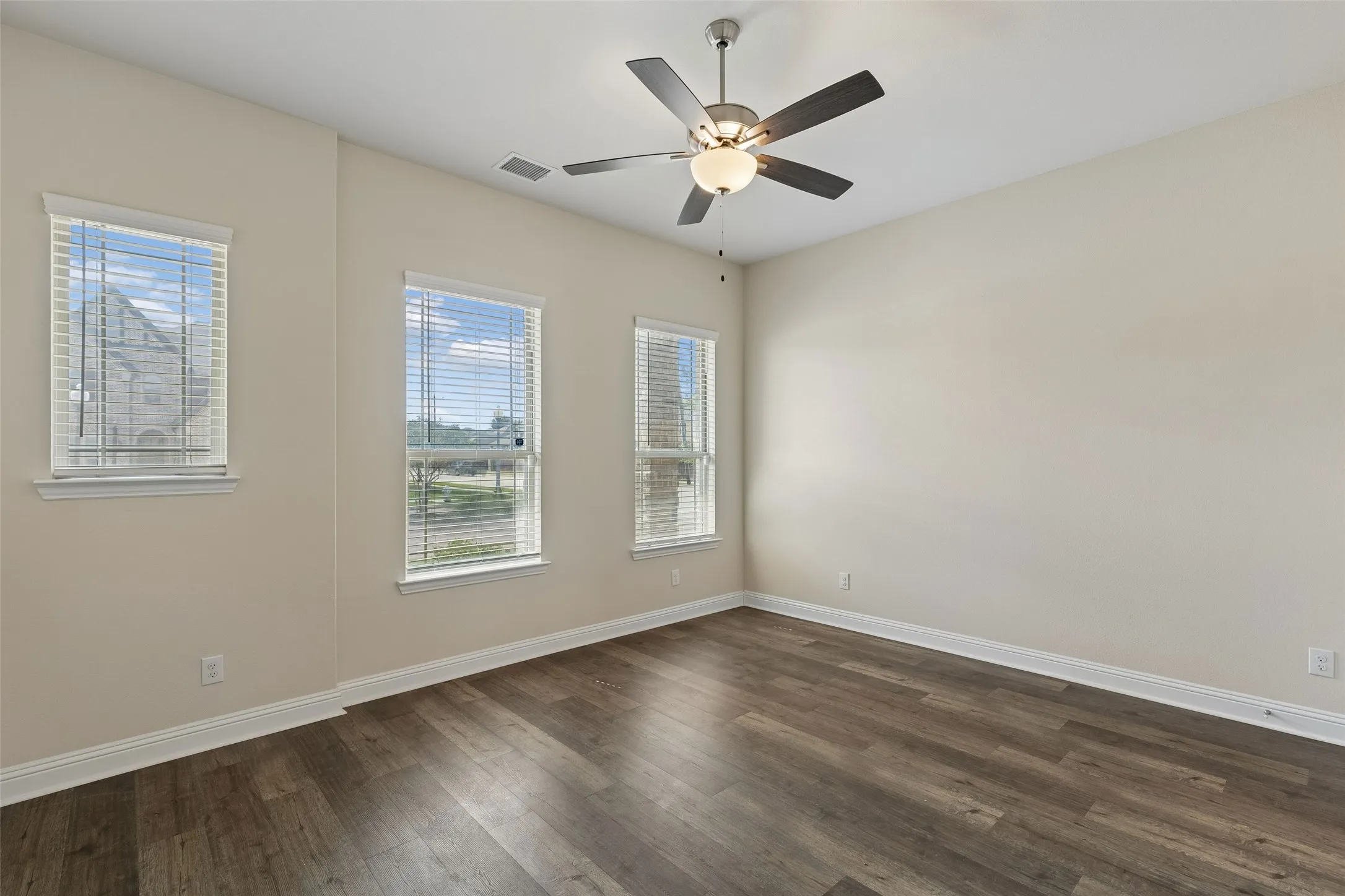 Primary bedroom featuring LVP flooring, high ceilings, plenty of natural light and an en suite bathroom.