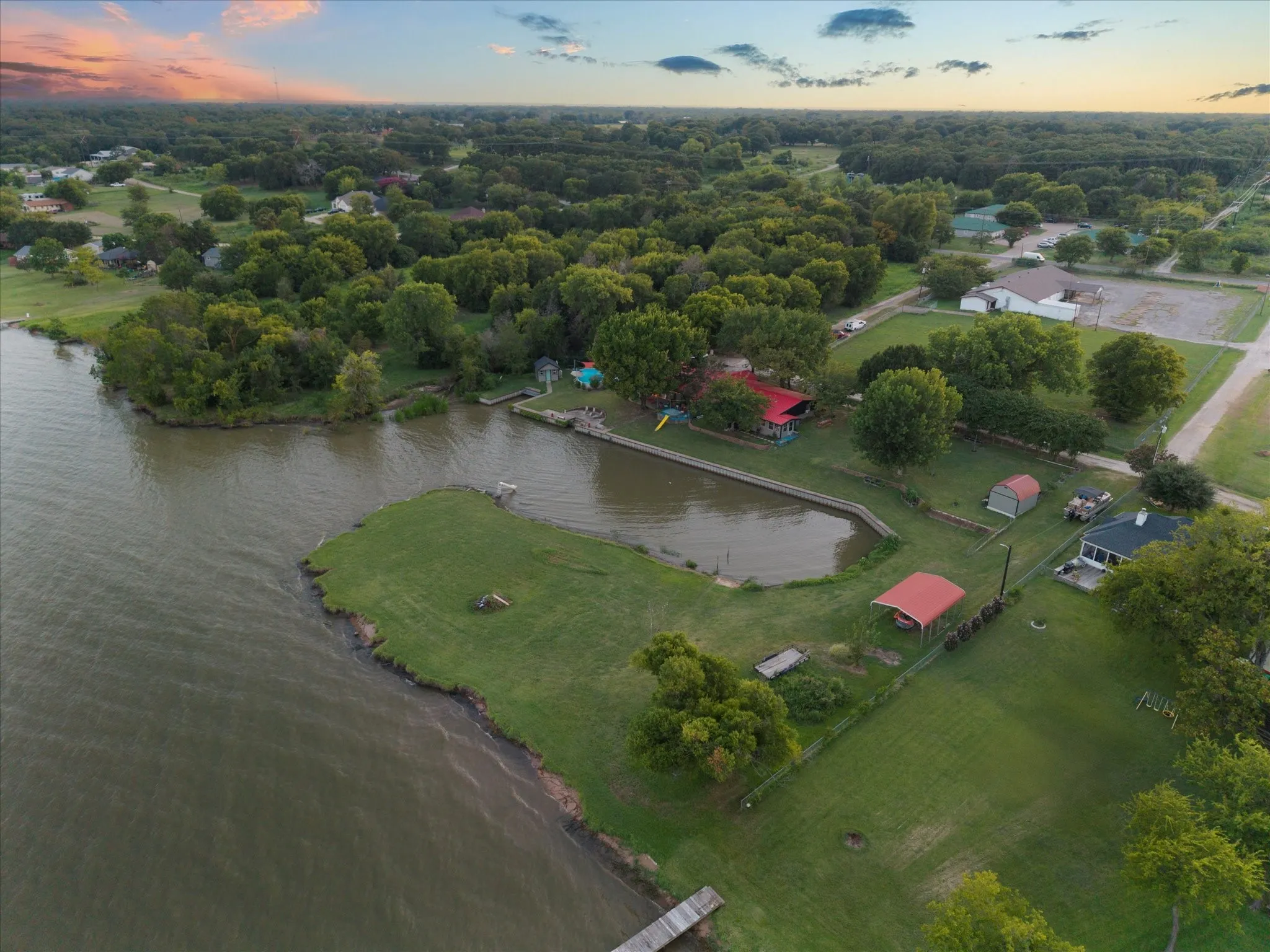 Expansive waterfront property with a private pond, green space, and mature trees