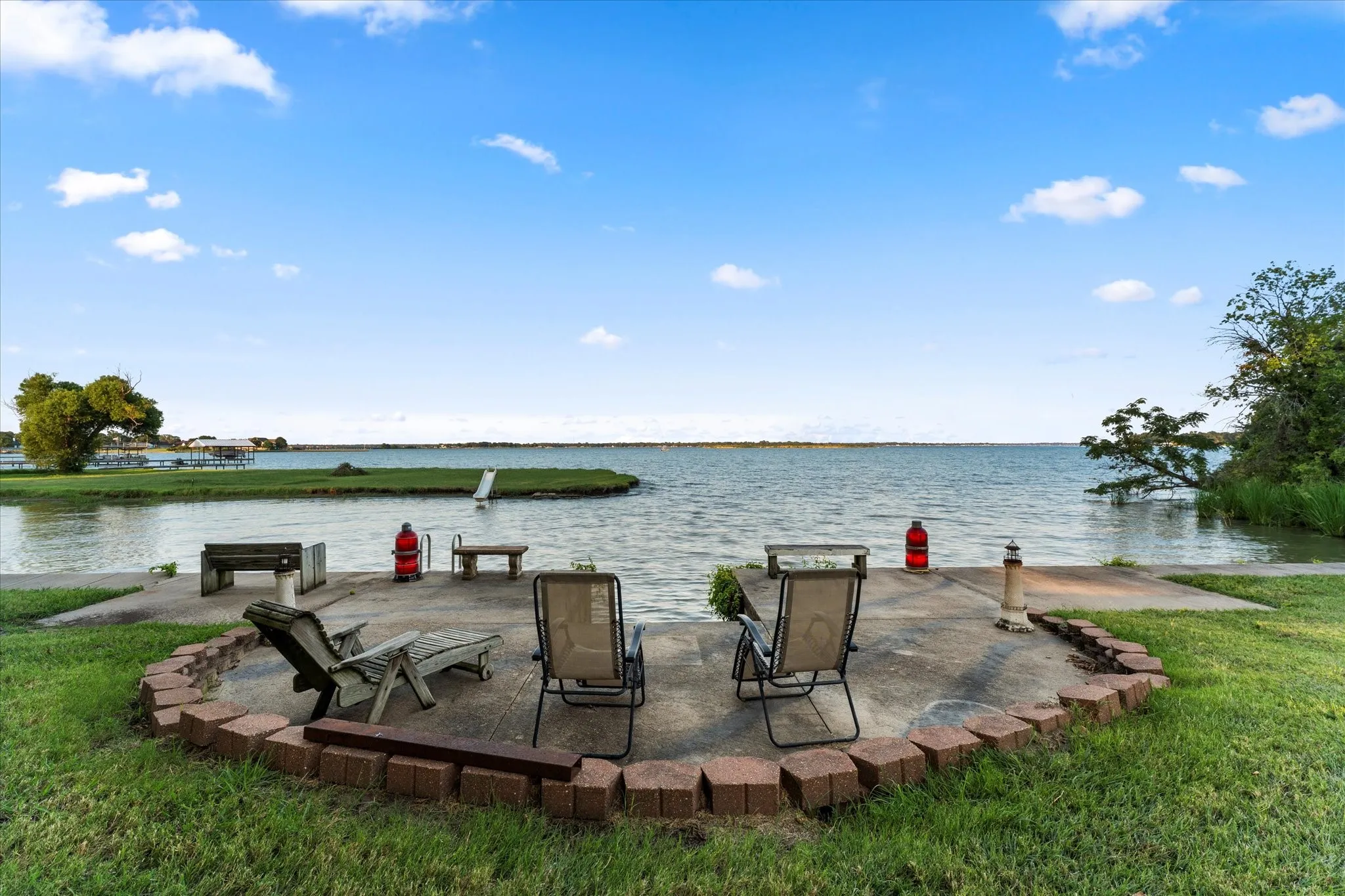 Concrete patio with brick paver border, featuring direct water access at full pool and a private dock