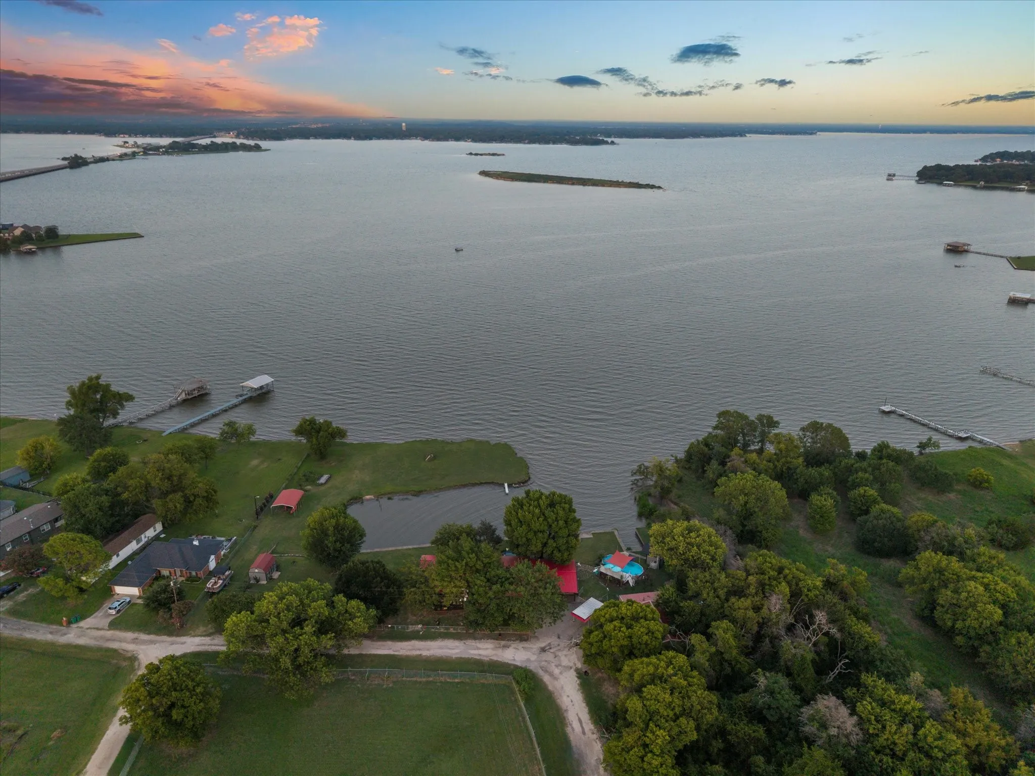 Waterfront property featuring multiple boat docks, a private pond, and expansive green spaces