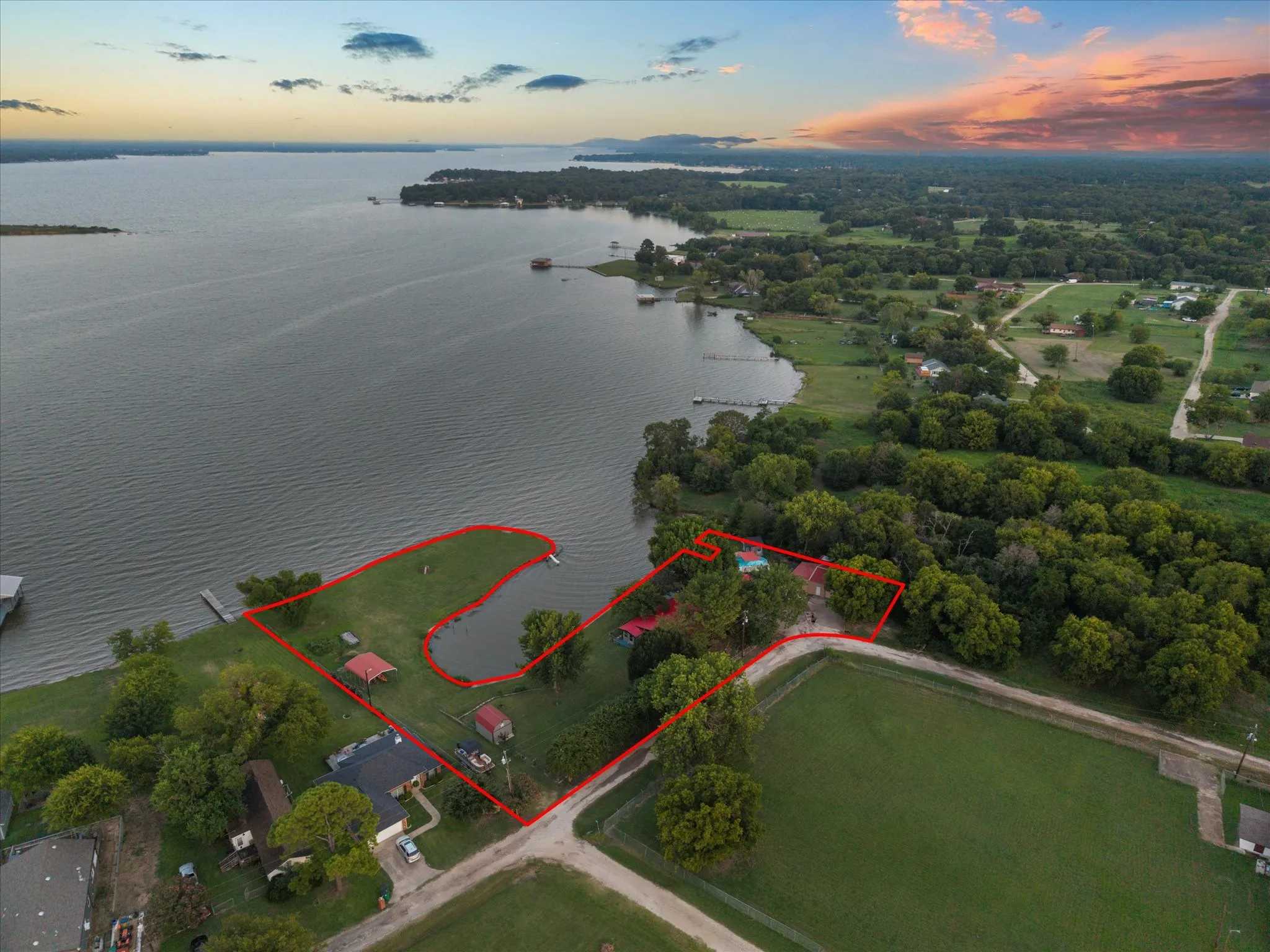 Waterfront property featuring extensive shoreline, private dock, and mature trees