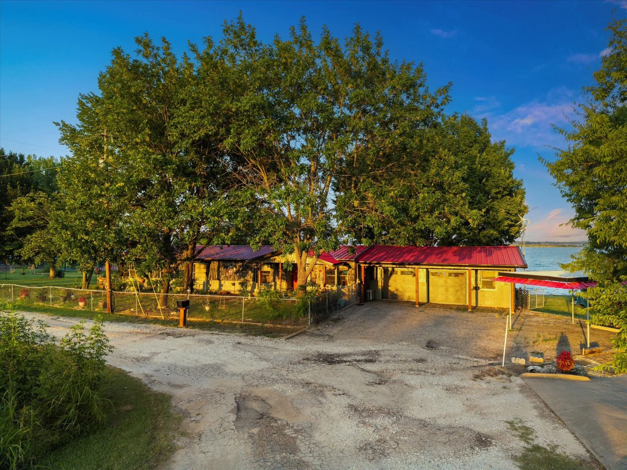 Red metal roofing accents the structure with a water backdrop