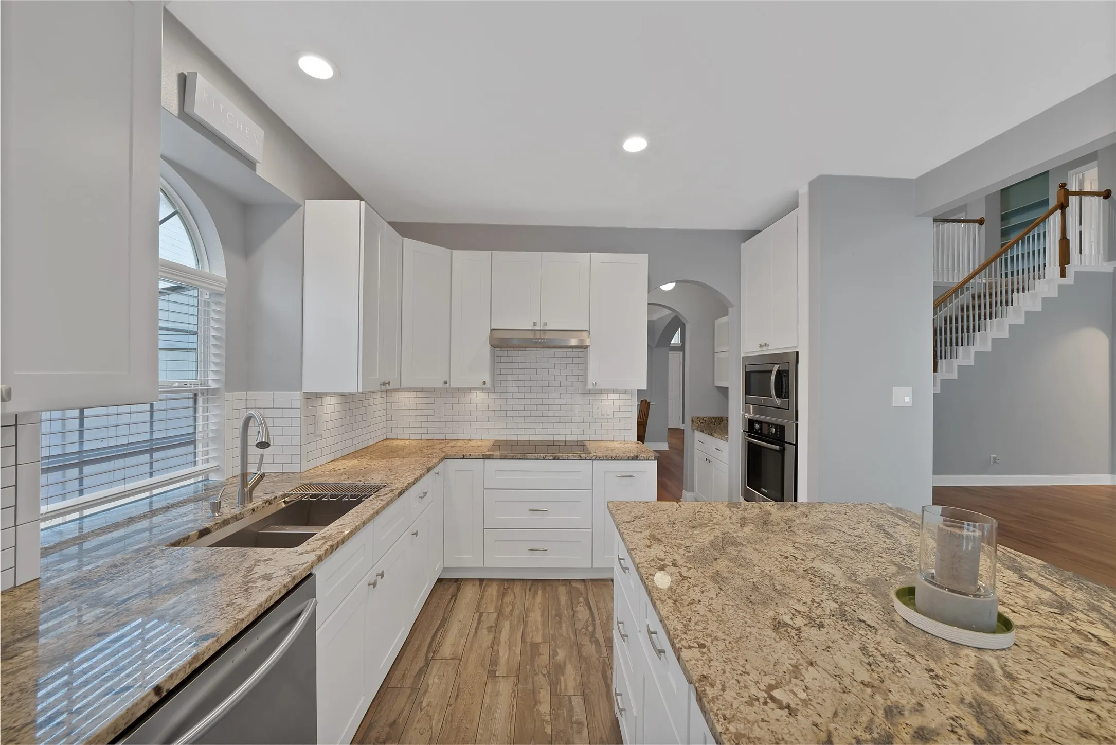 White cabinetry and granite countertops with a subway tile backsplash
