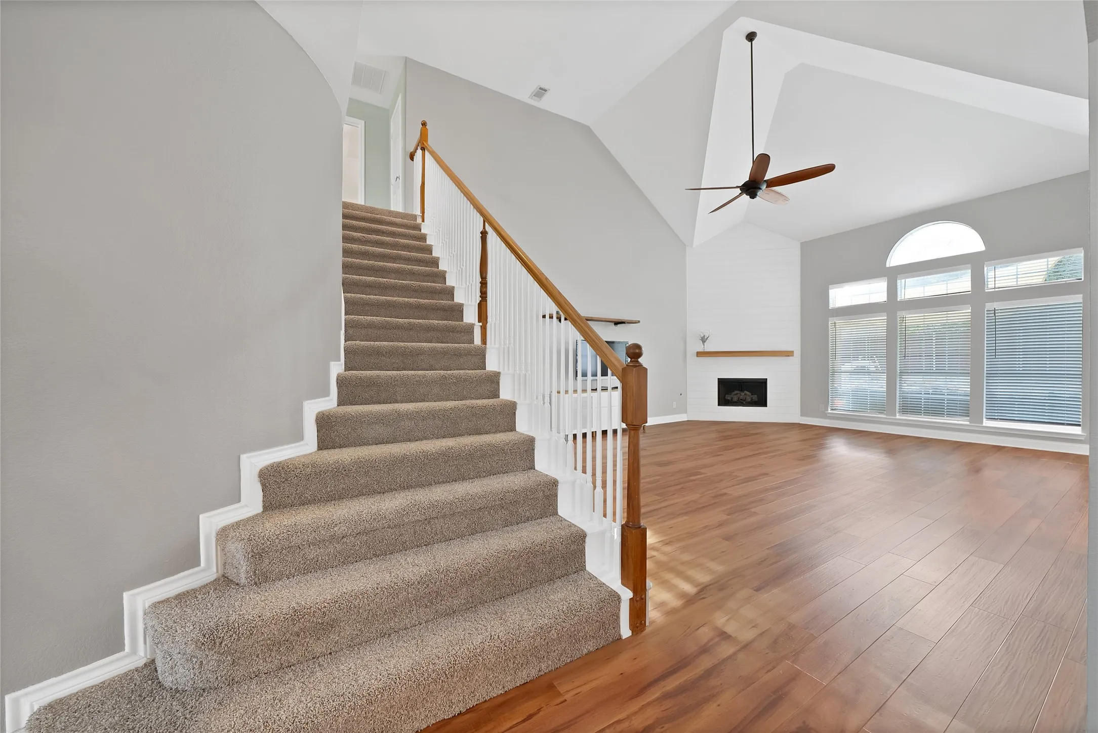 Vaulted ceilings, wood-finish flooring, fireplace, large windows with an arched transom, and a ceiling​​‌​​​​‌​​‌‌​‌‌​​​‌‌​‌​‌​‌​​​‌​​ fan