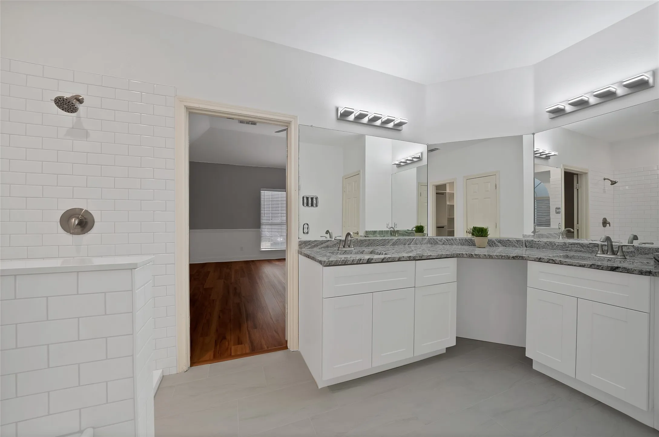 Dual vanity with undermount sinks, granite-style countertops, and expansive mirrors